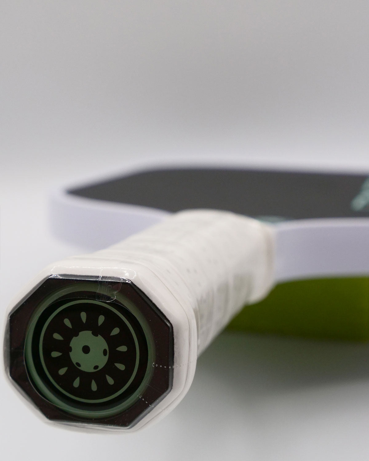 Close-up of a new pickleball paddle with a kiwi design on the grip.