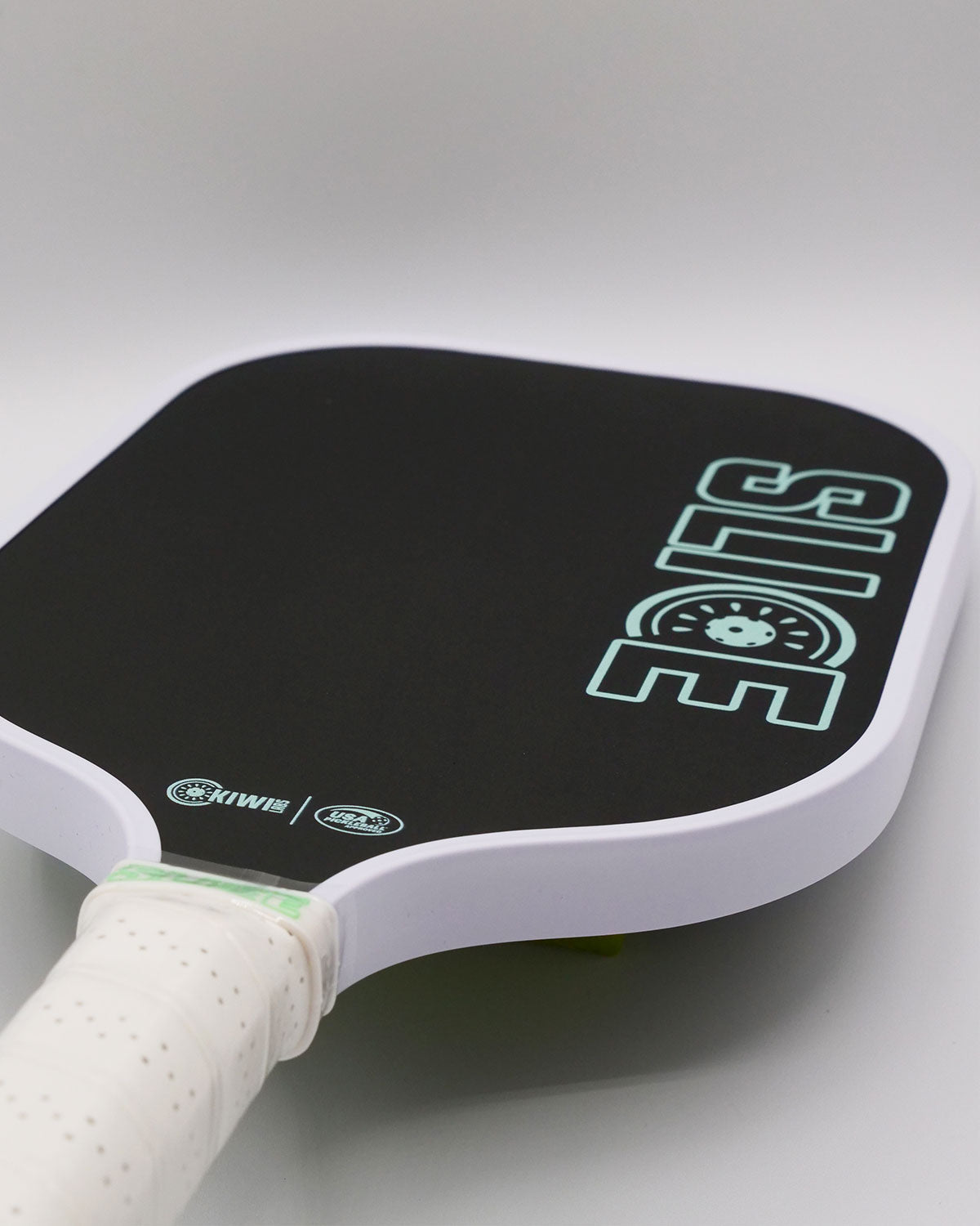 Black and white pickleball paddle with green "SLICE" logo.