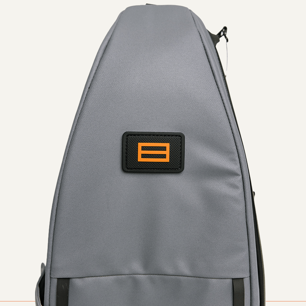 Gray bag with a black patch featuring two orange horizontal lines.