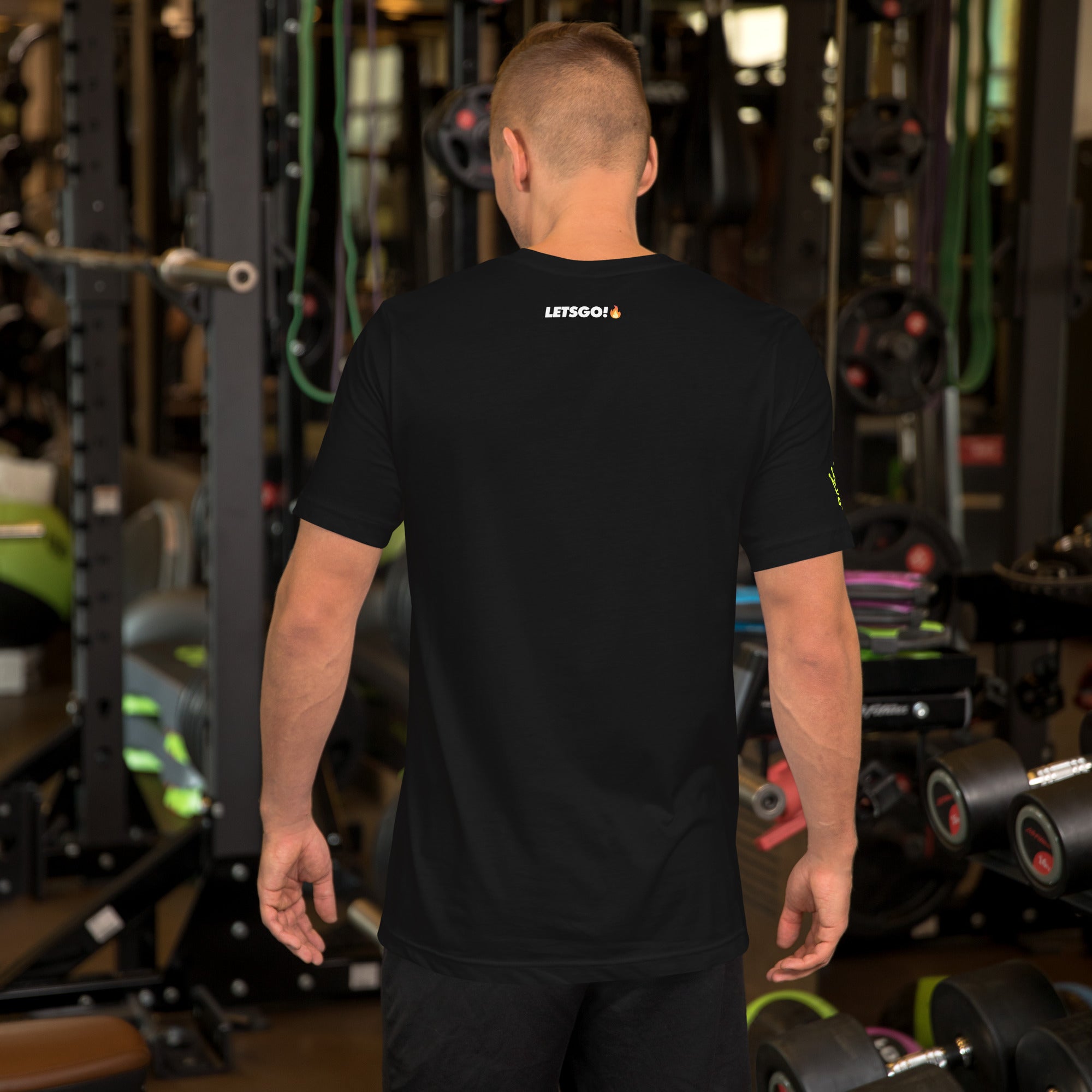 A person facing away wearing a black T-shirt in a gym.