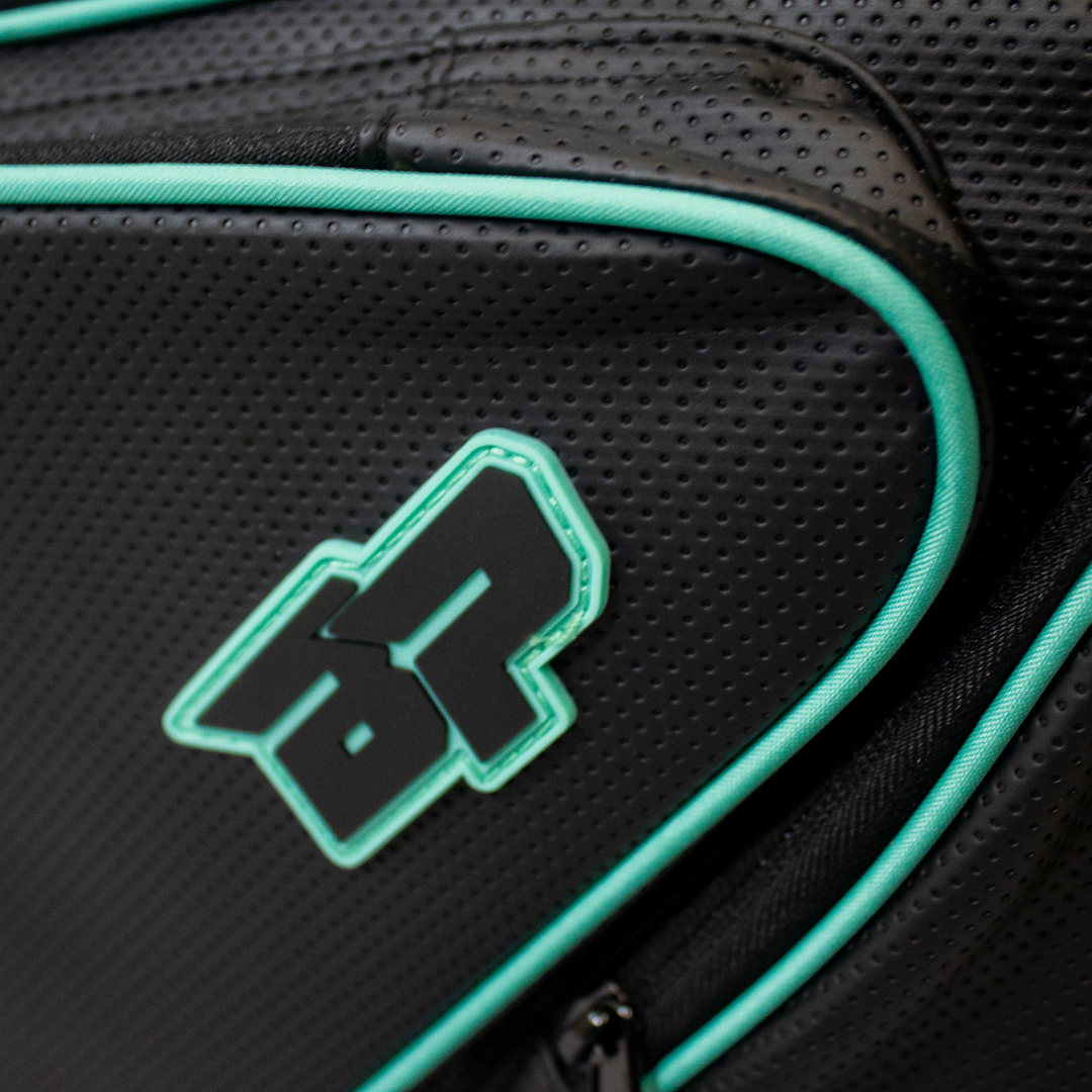 Black perforated duffle bag by Bodhi Pickleball with mint green piping and embossed 'BP' logo.