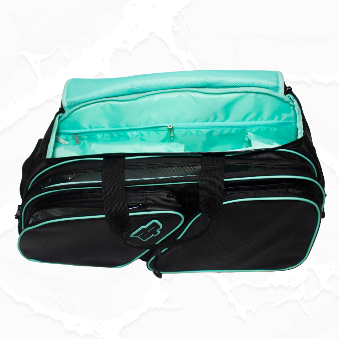 Black fabric duffle bag with teal accents by Bodhi Pickleball, open showing bright teal interior, mesh pocket, and pocket logo.