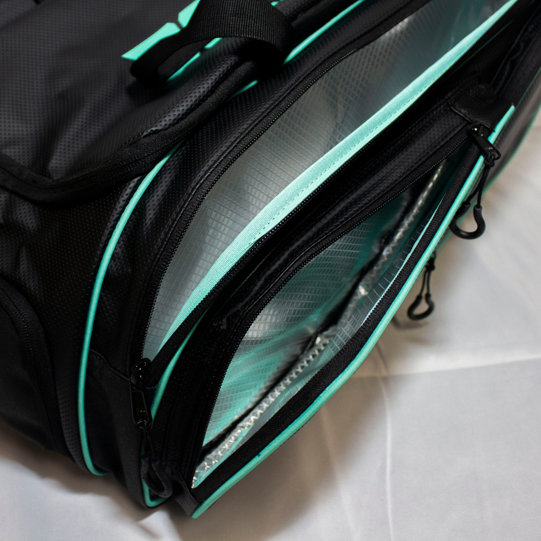 Black duffle bag by Bodhi Pickleball with teal accents, multiple open insulated compartments, and textured material.