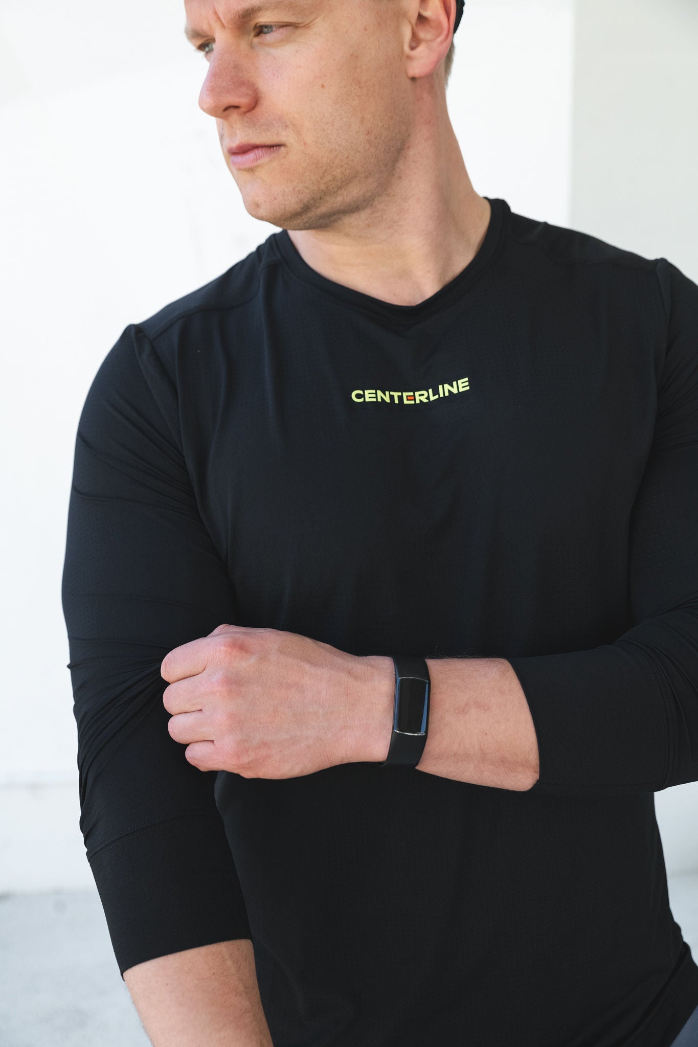 Man in black long-sleeved shirt with fitness tracker.