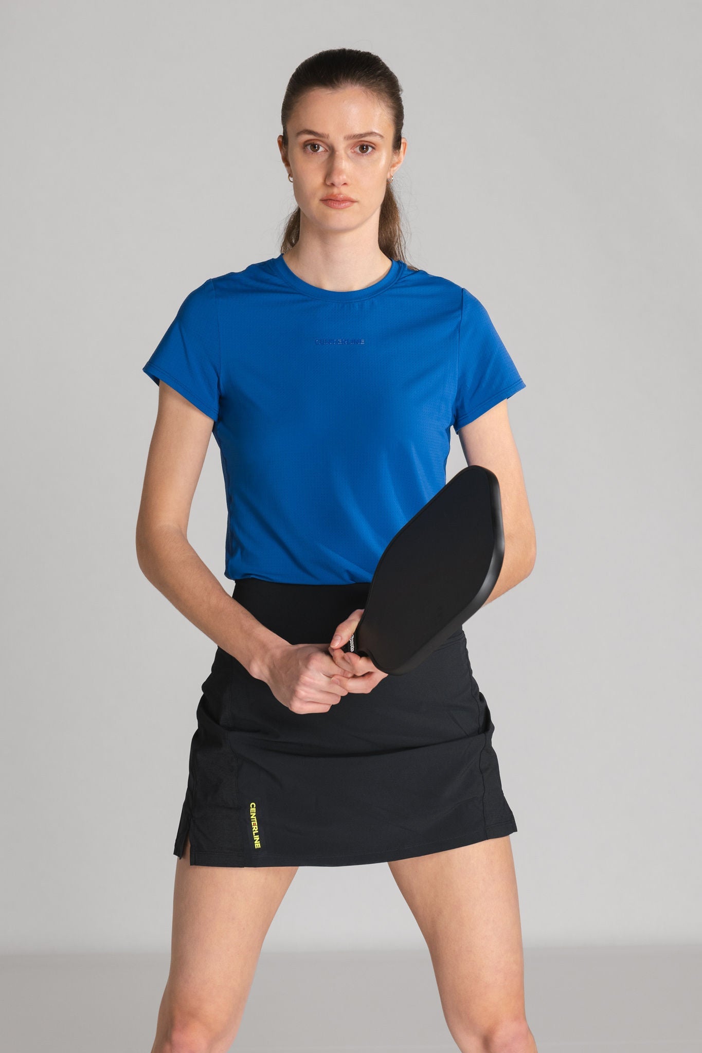 Woman in athletic wear holding a paddle.