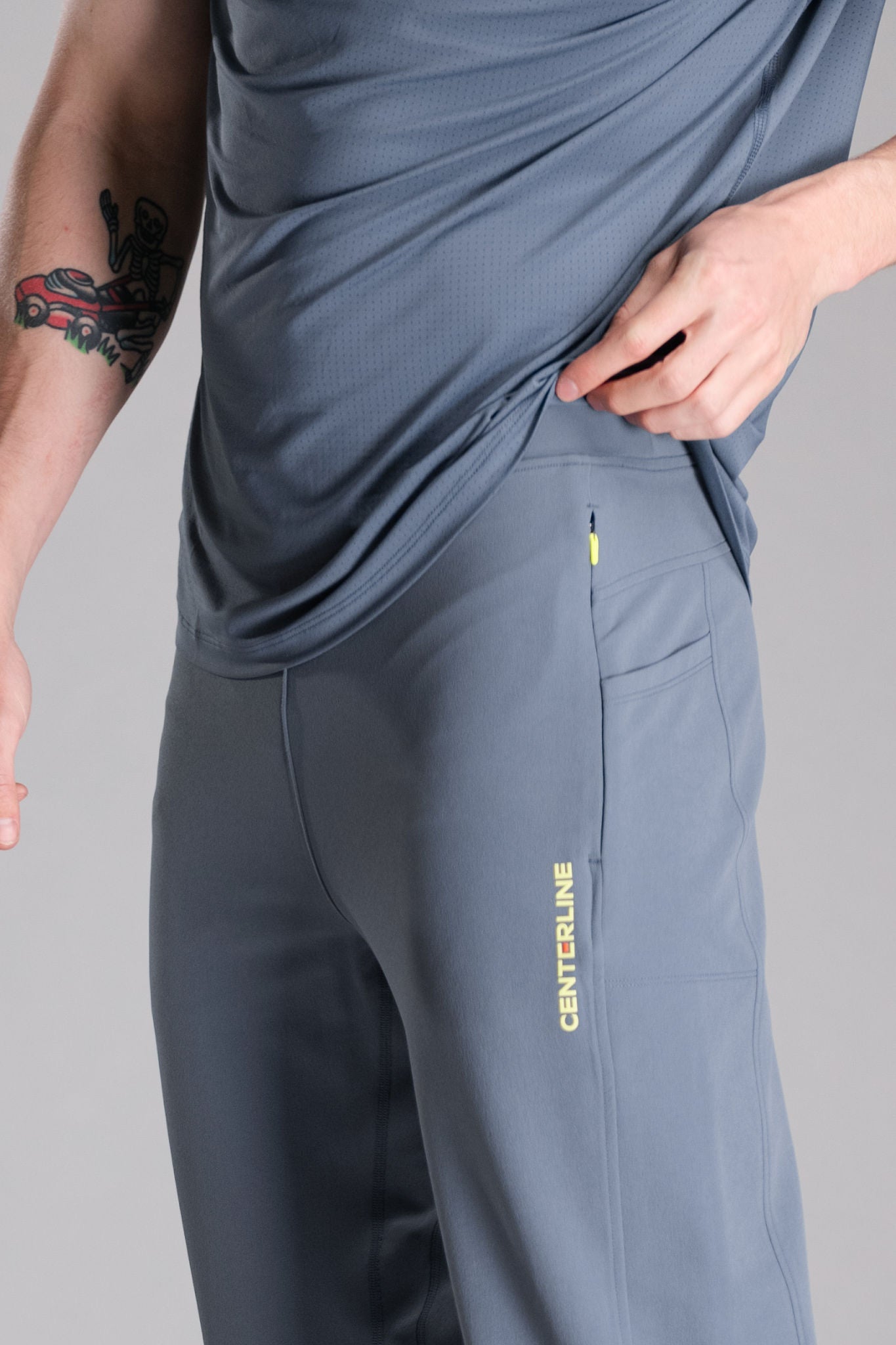 Man in gray athletic wear with a tattoo on his left arm.