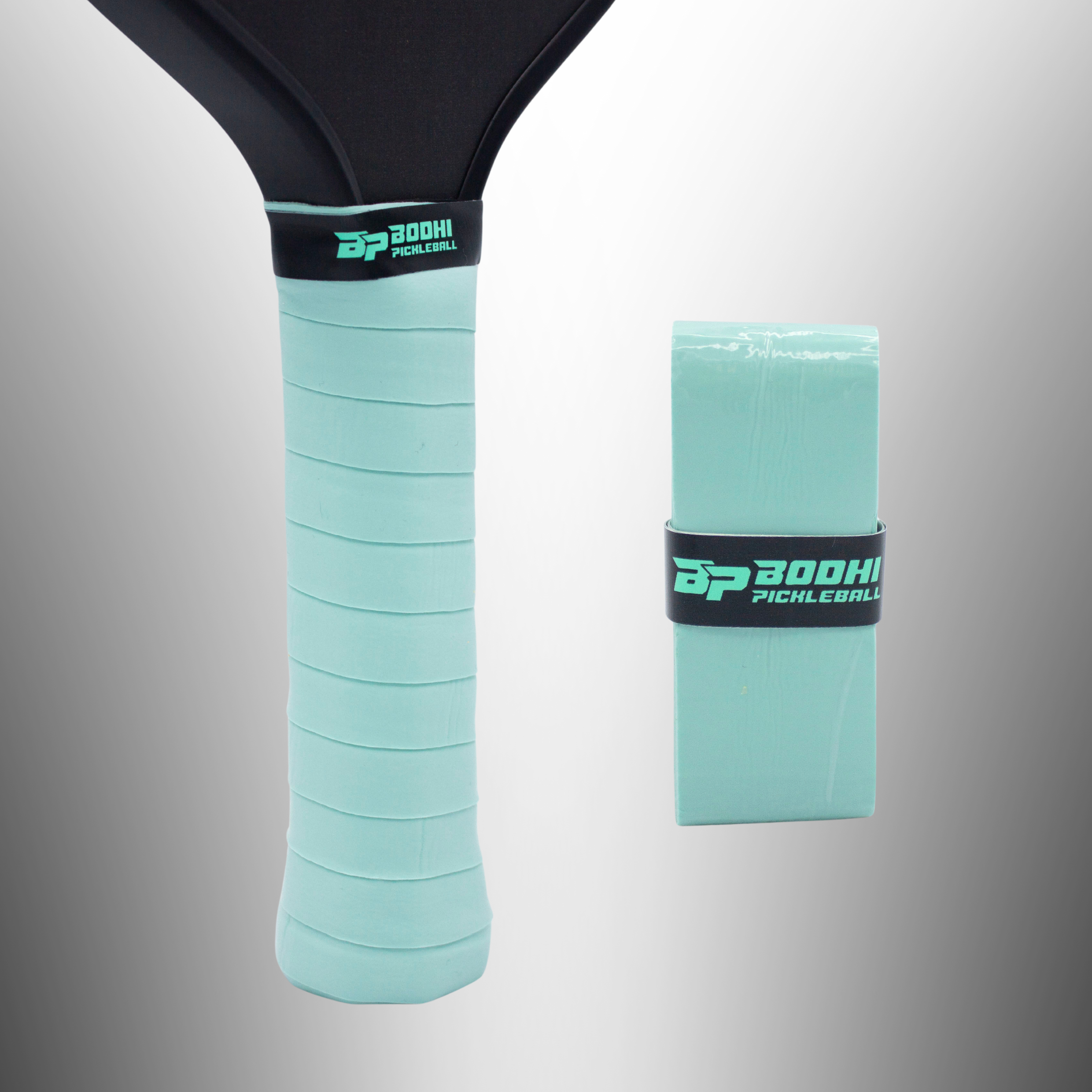 Mint green pickleball paddle overgrip by Bodhi Pickleball, applied to a black paddle handle, with a matching packaged overgrip beside it.