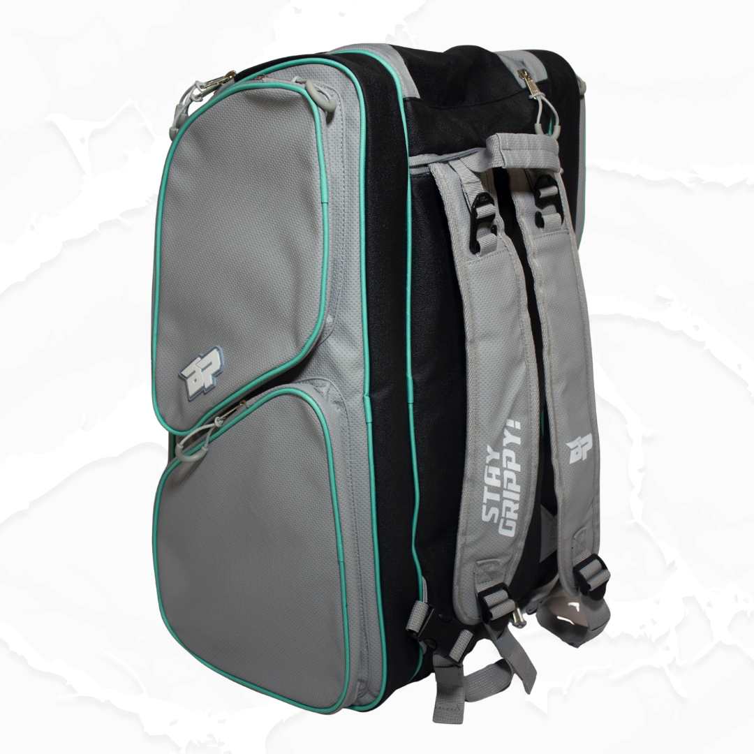 Grey and black duffle bag by Bodhi Pickleball with turquoise piping, "STAY GRIPPY!" text on the strap, and "BP" logos on the pockets, viewed from the side.