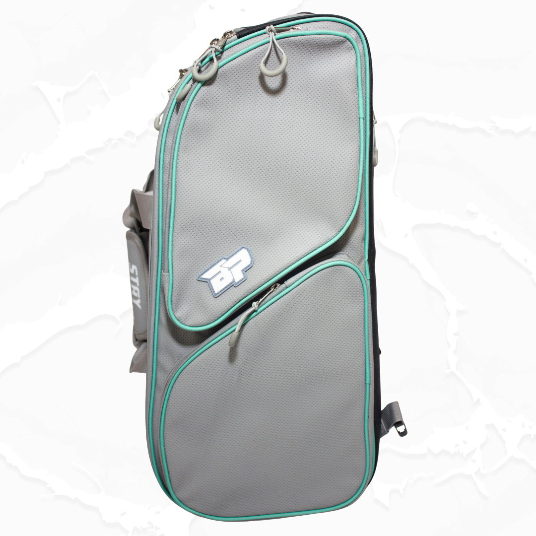 Grey duffle bag by Bodhi Pickleball with aqua trim, textured fabric, asymmetrical zippered pockets, and 'BP' logo.