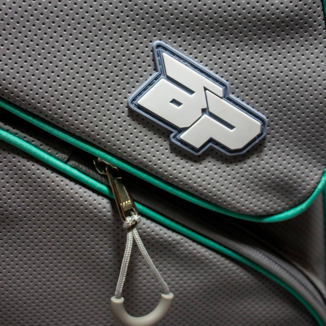 Grey perforated duffle bag by Bodhi Pickleball with a green zipper trim and a grey "BP" logo.