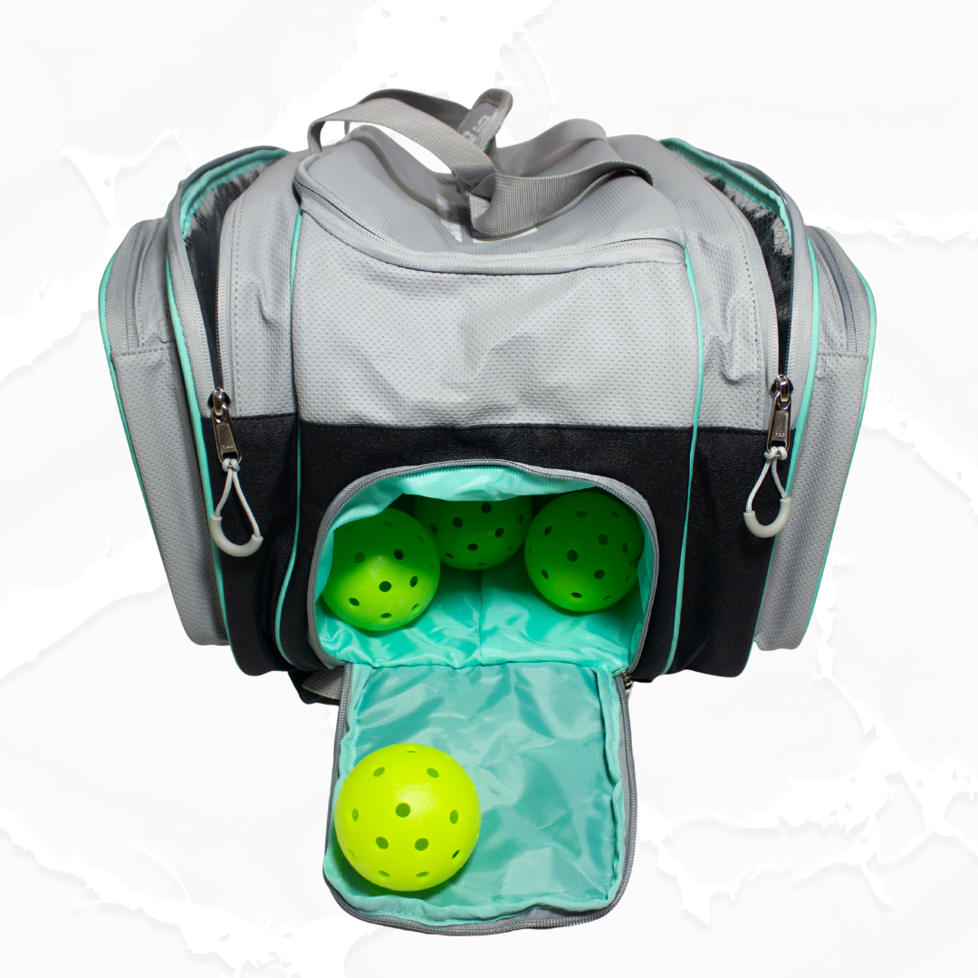Grey and black sports duffle bag by Bodhi Pickleball with mint green accents, featuring an open pocket with four neon green pickleball balls.