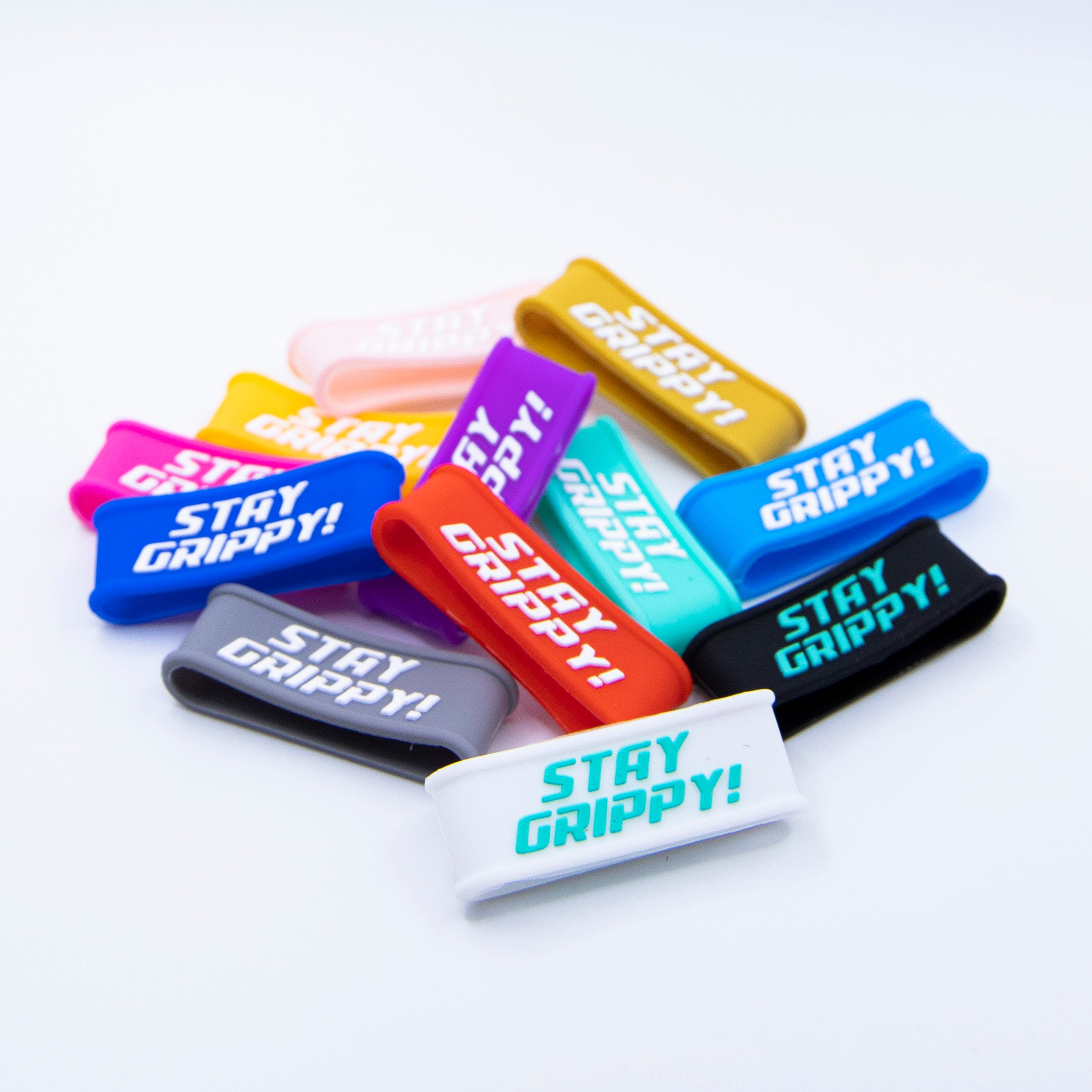 Colorful "Stay Grippy!" wristbands in a pile on a white surface.