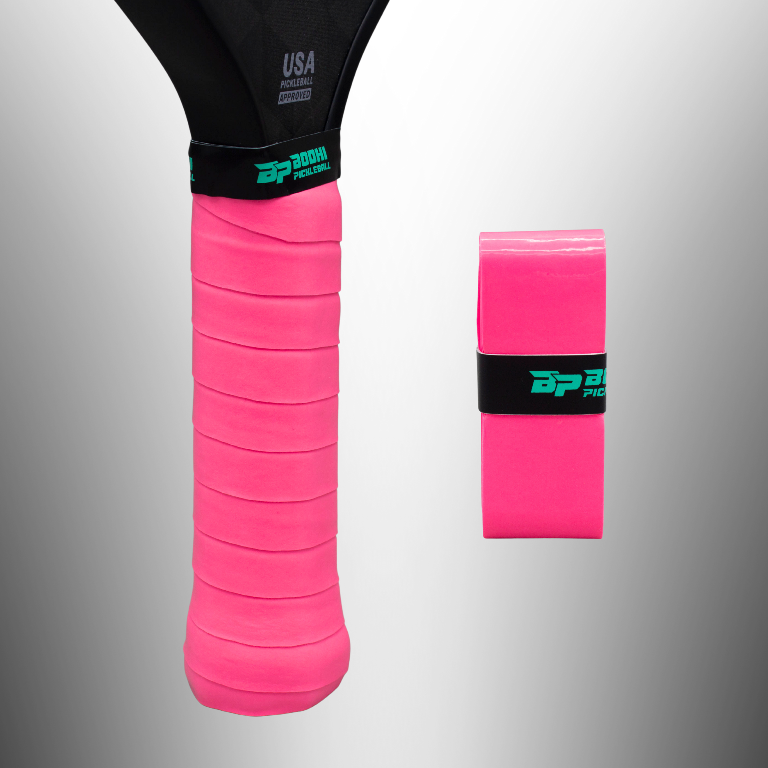 Bright pink pickleball paddle overgrips by Bodhi Pickleball, one wrapped on a black handle with teal logo, one rolled.