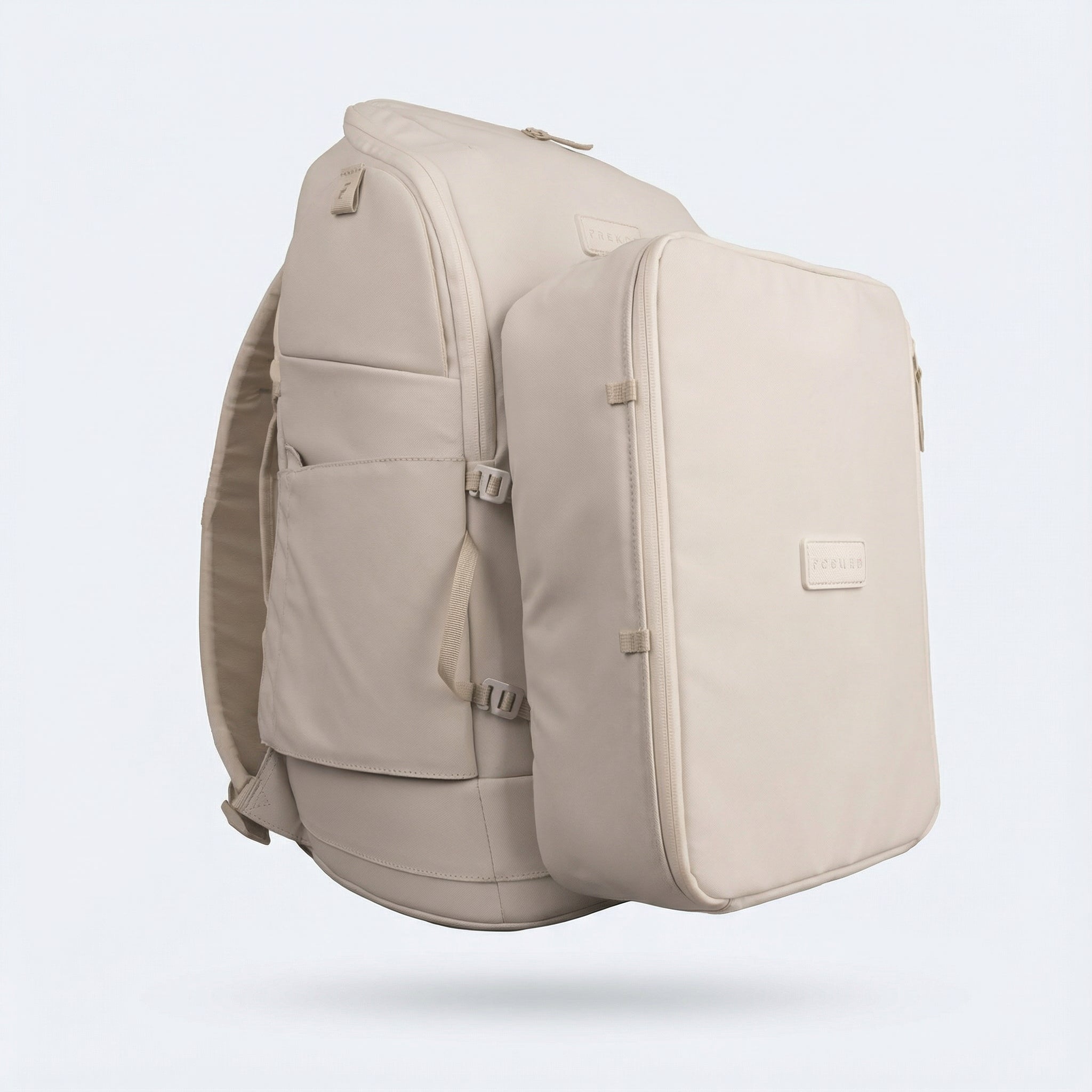 Light beige fabric shoe cube by FORWRD, with debossed logo and zippered opening, attached to a large matching backpack.
