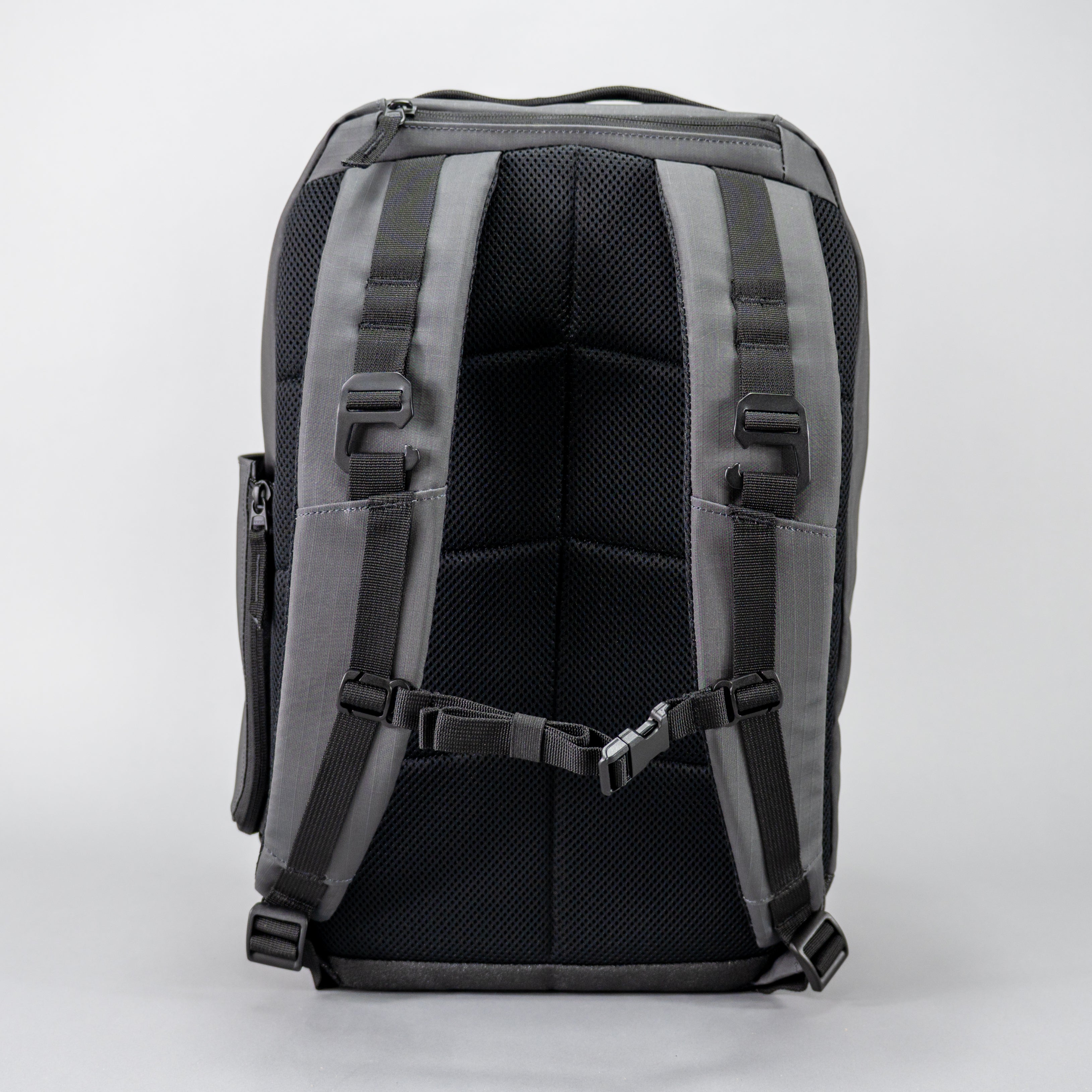Back view of a gray backpack with black mesh panel and adjustable straps.