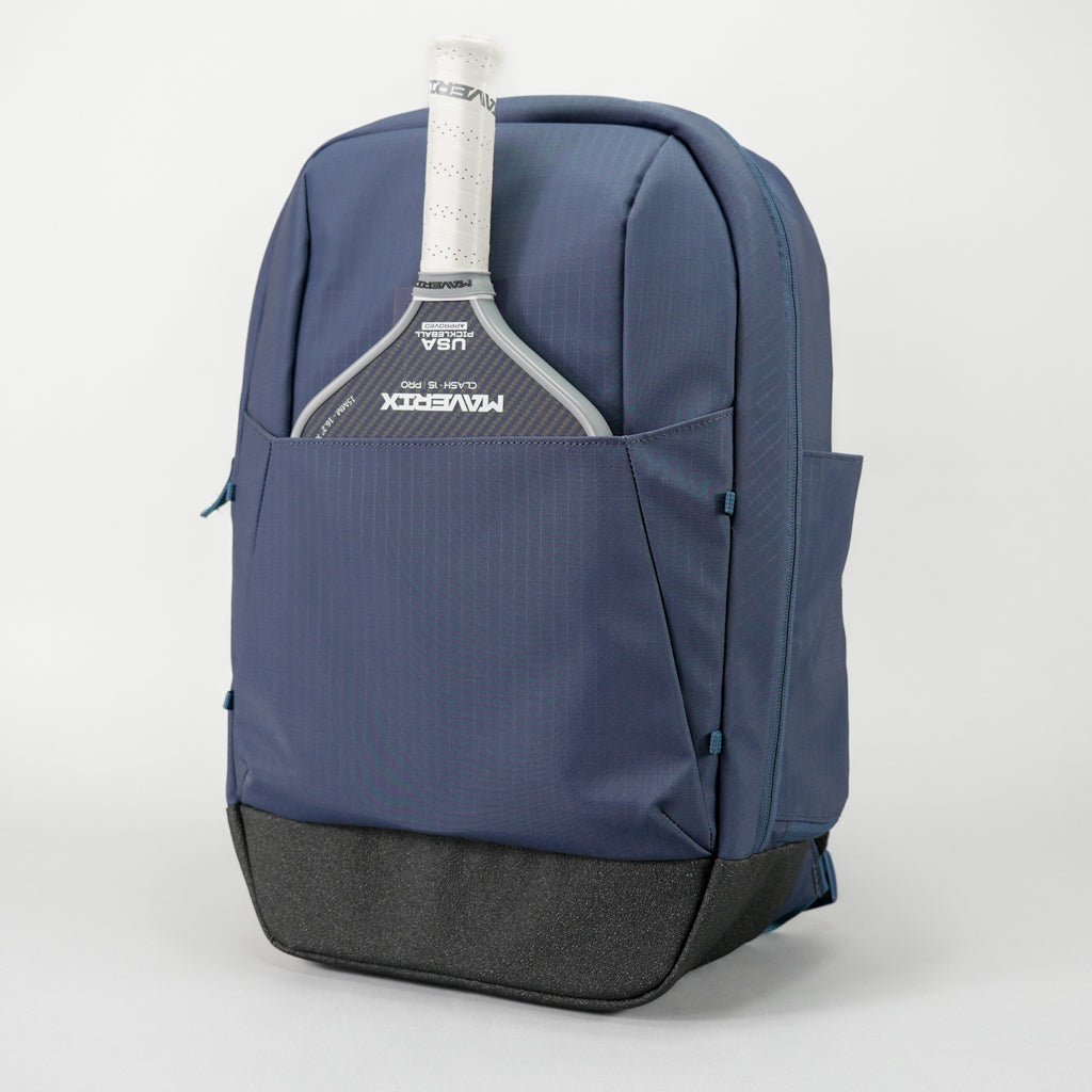 Navy blue textured pickleball backpack by FORWRD, with a black bottom and a paddle in the front pocket.