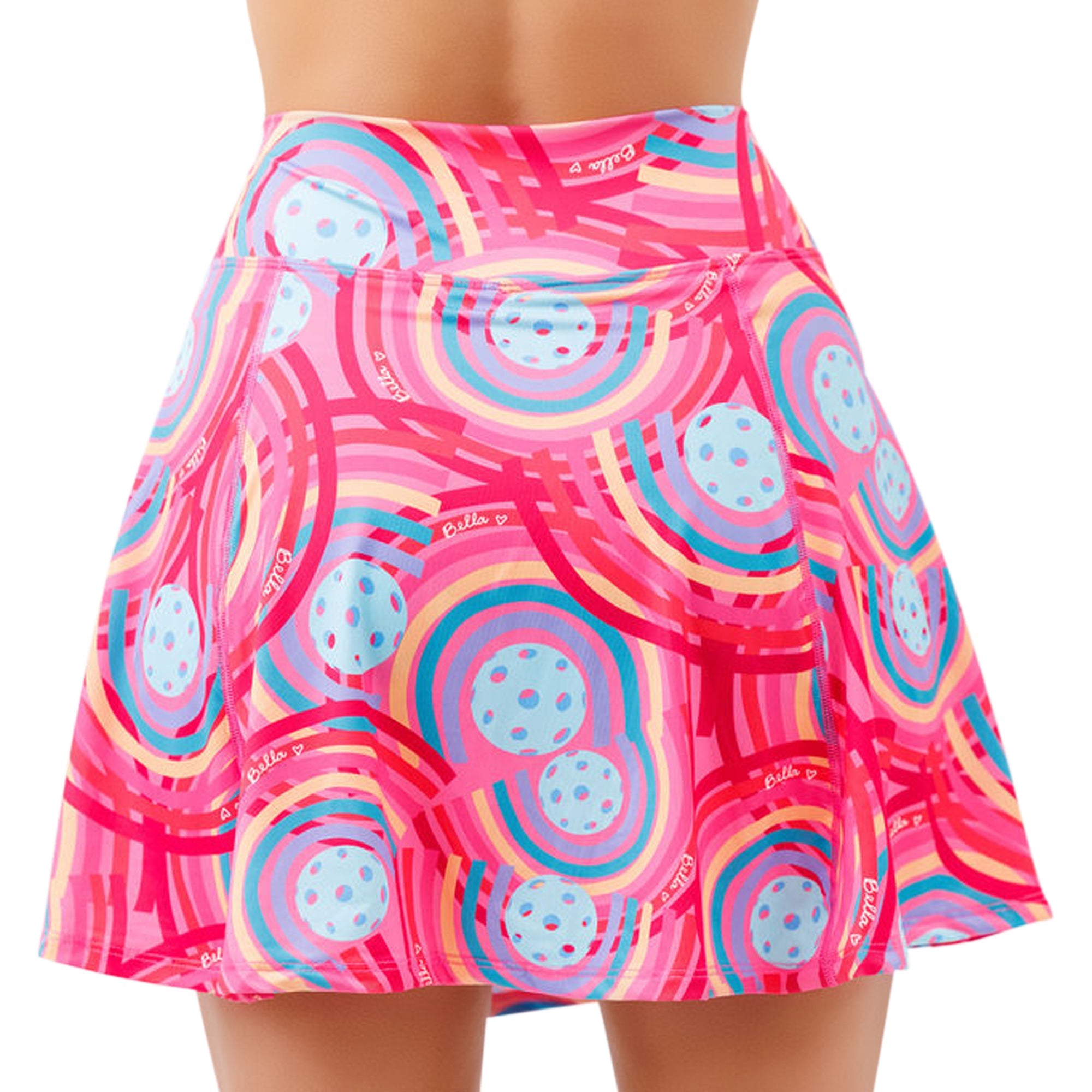 Pink A-line skort by Pickleball Bella, featuring colorful rainbow circles, light blue pickleball motifs, and 'Bella' text.