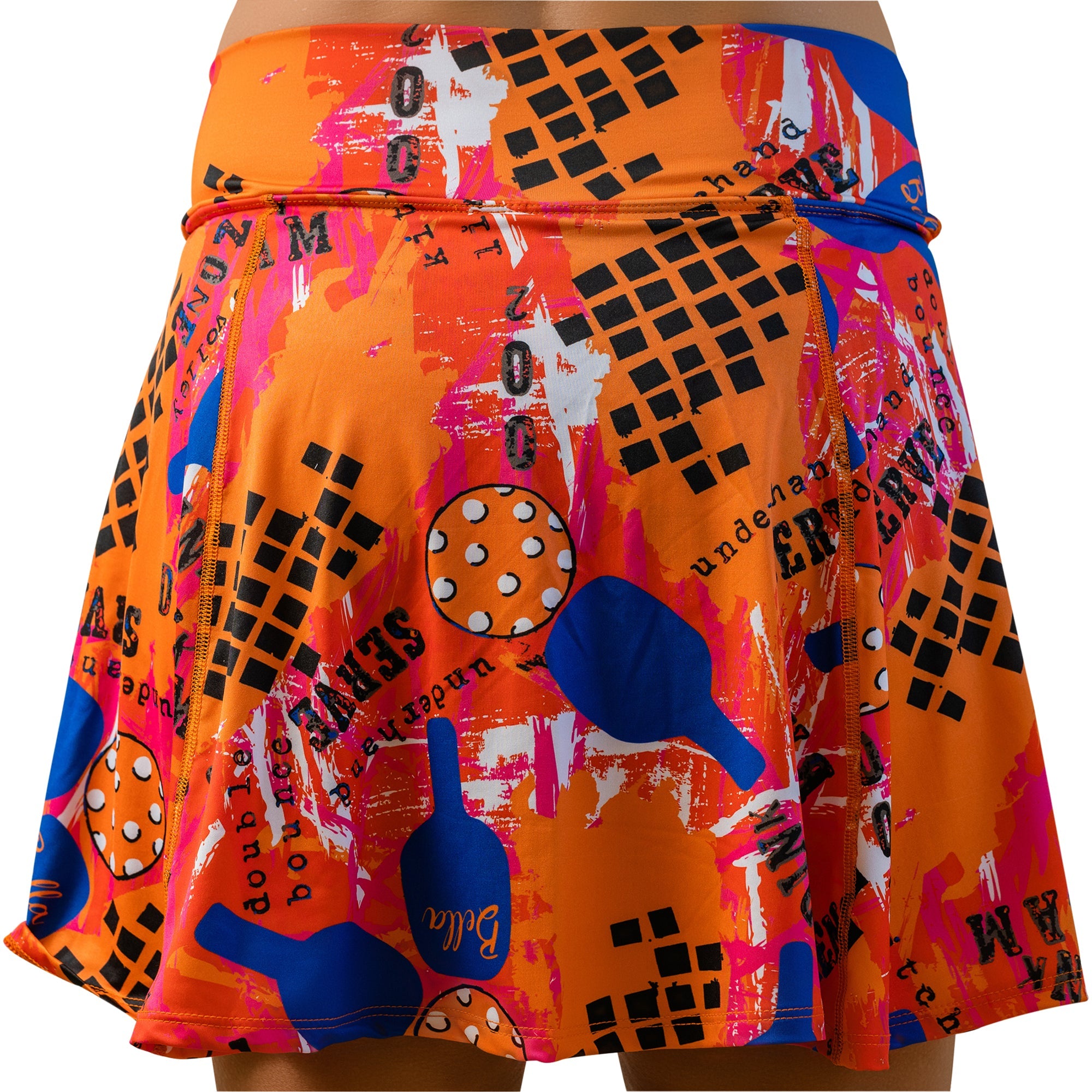 Orange A-line skort by Pickleball Bella with vibrant graffiti print featuring paddles, a ball, and abstract text.