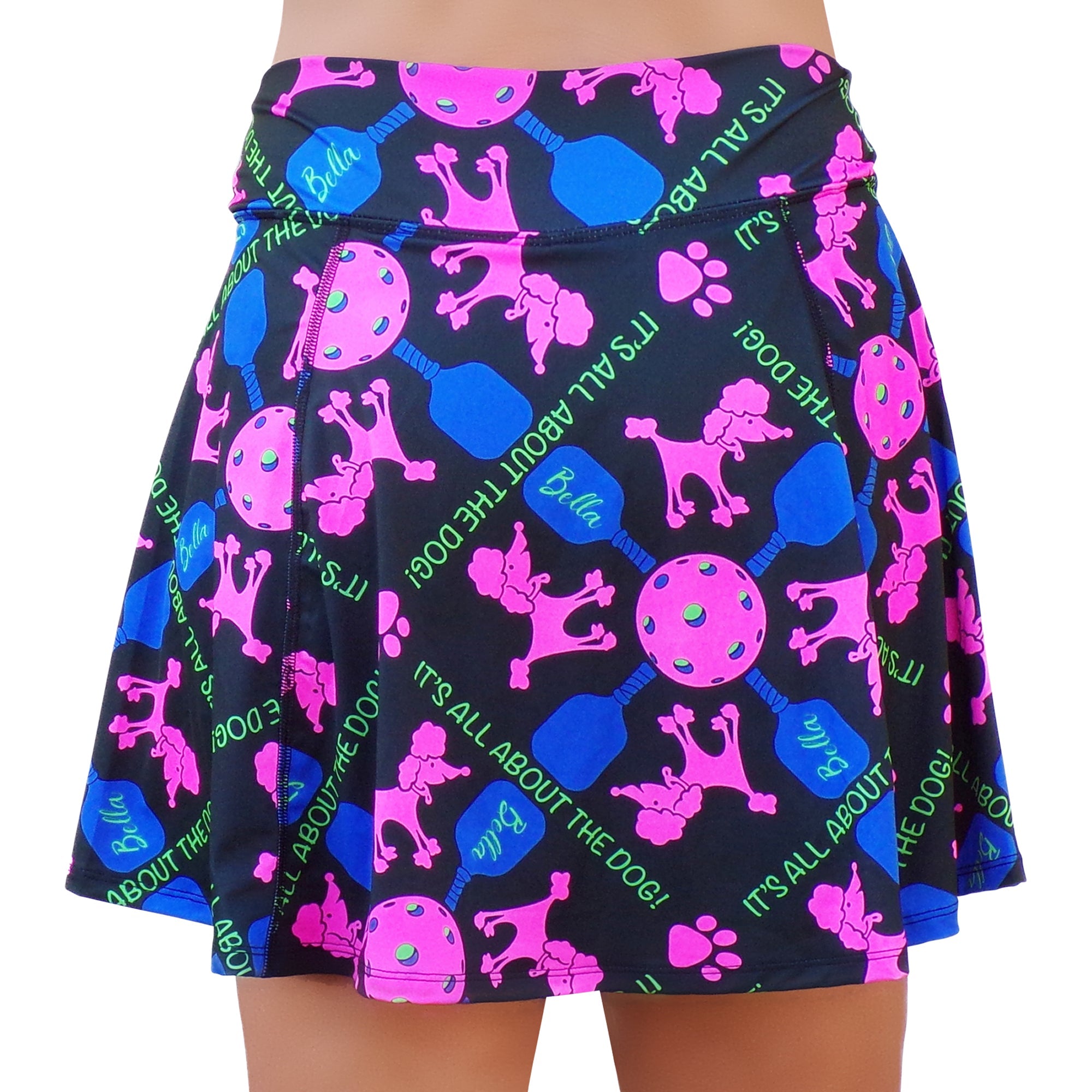 Black A-Line skort by Pickleball Bella featuring pink poodles, pickleball gear, paw prints, and "IT'S ALL ABOUT THE DOG!" text.