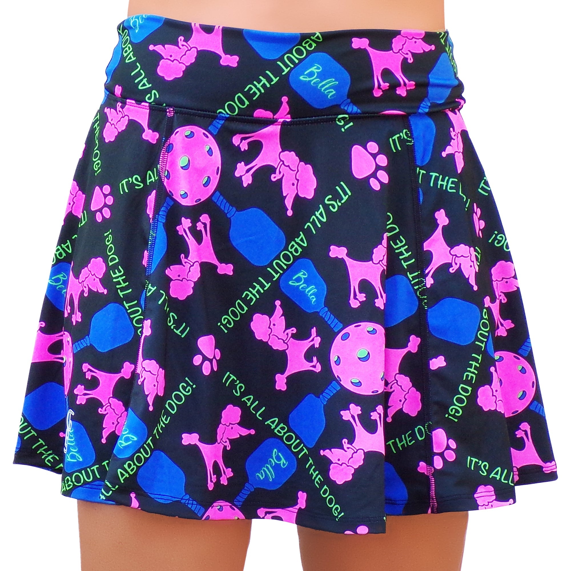 Black A-line skort by Pickleball Bella featuring pink poodles, blue pickleball paddles, and green "IT'S ALL ABOUT THE DOG!" text.