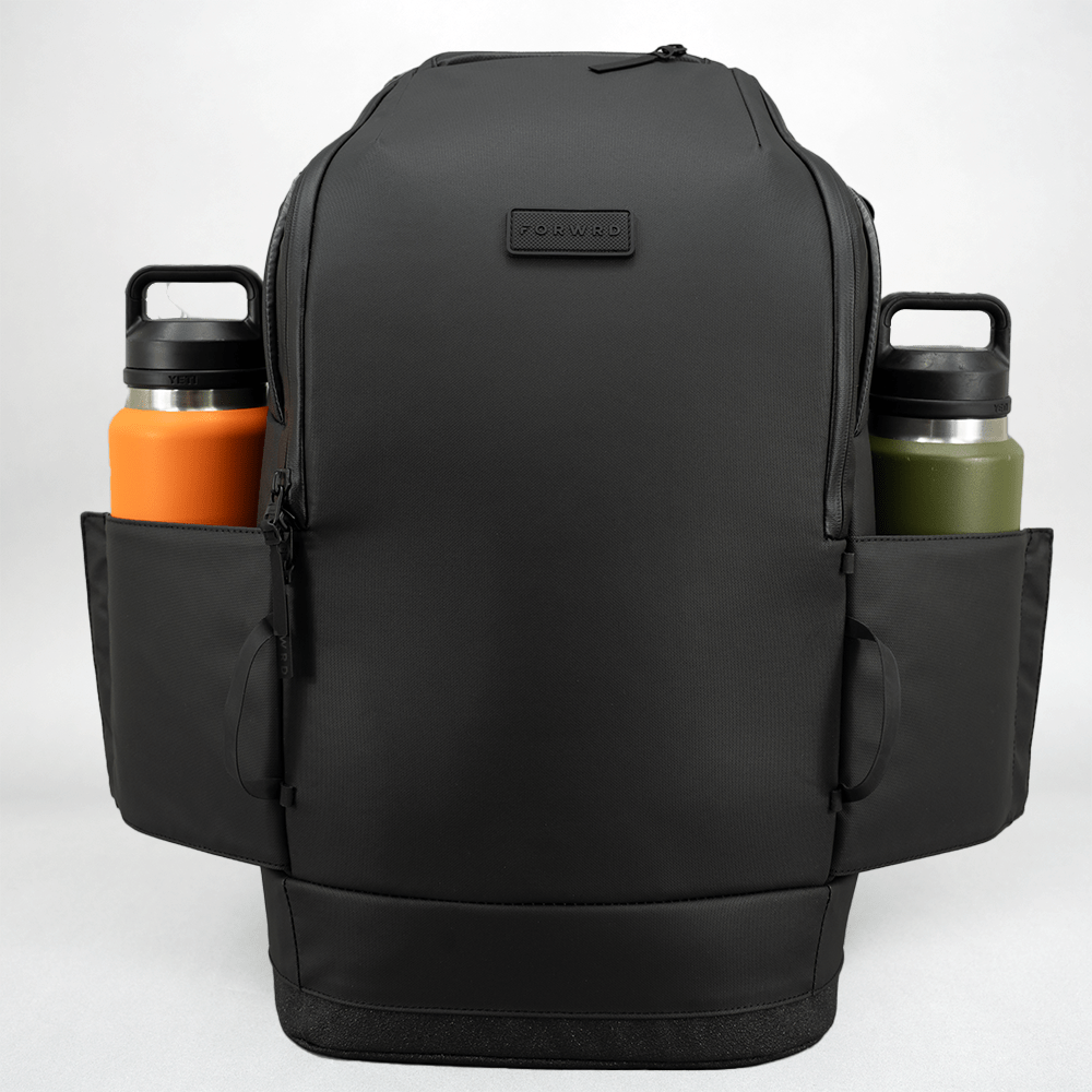 Black pickleball backpack by FORWRD, with two side pockets holding an orange and a green water bottle, front view.
