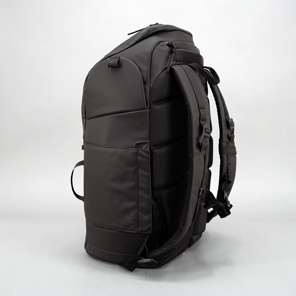 Black pickleball backpack by FORWRD, side view with padded back panel open and shoulder straps.