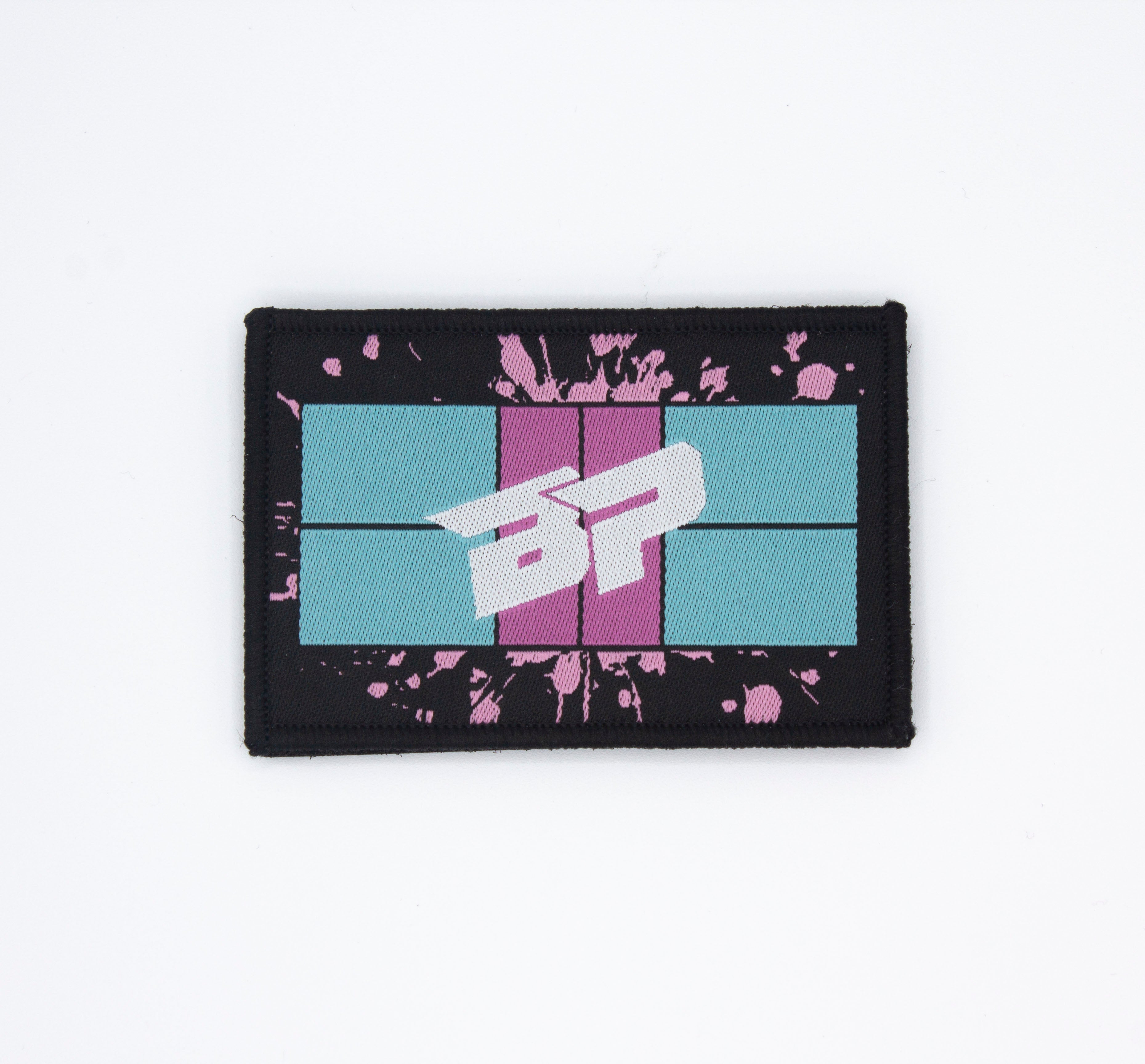 Black rectangular Velcro patch by Bodhi Performance with teal and pink stripes, a white 'BP' logo, and pink splatter details.