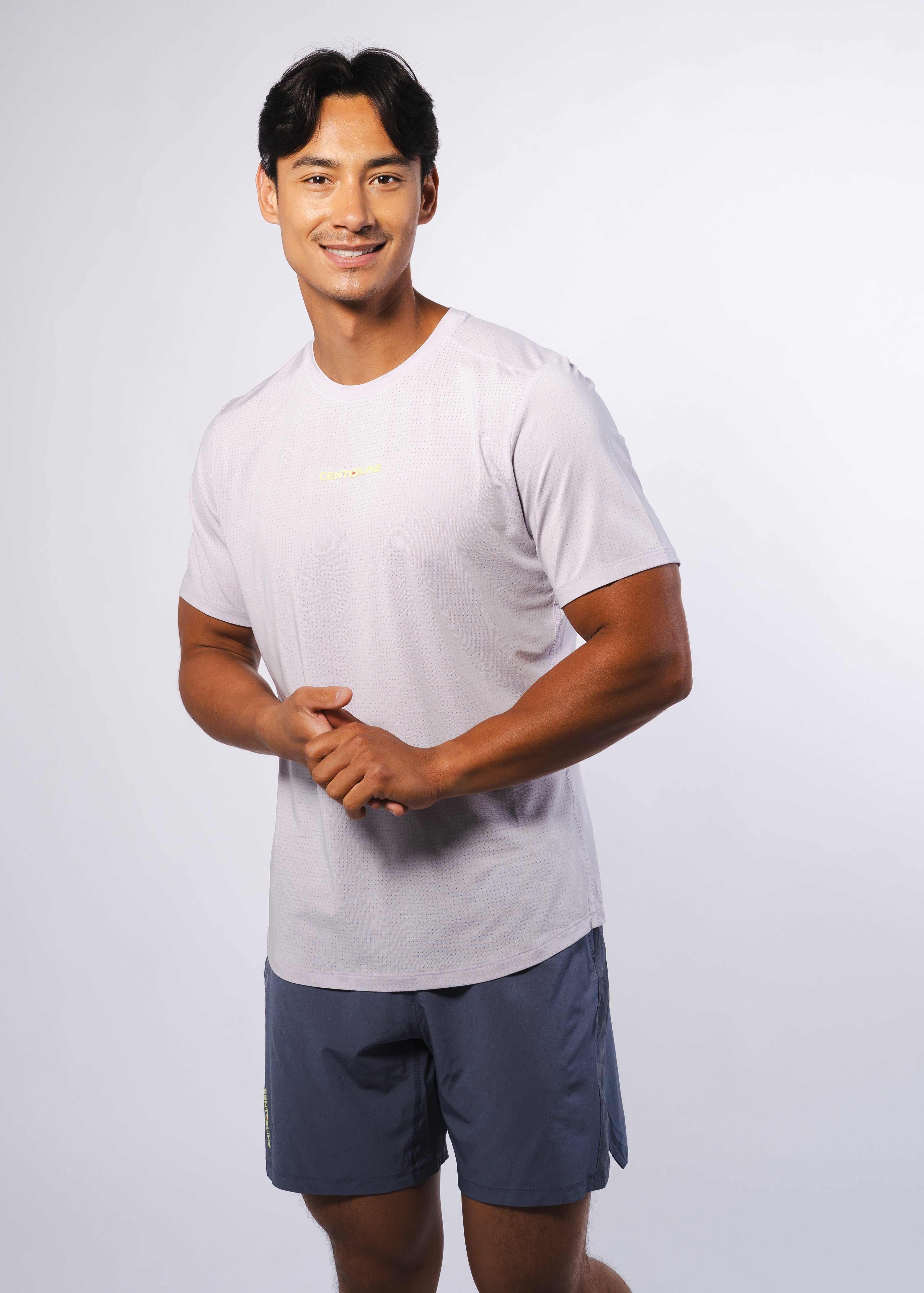 Man in athletic wear, light gray shirt and blue shorts.