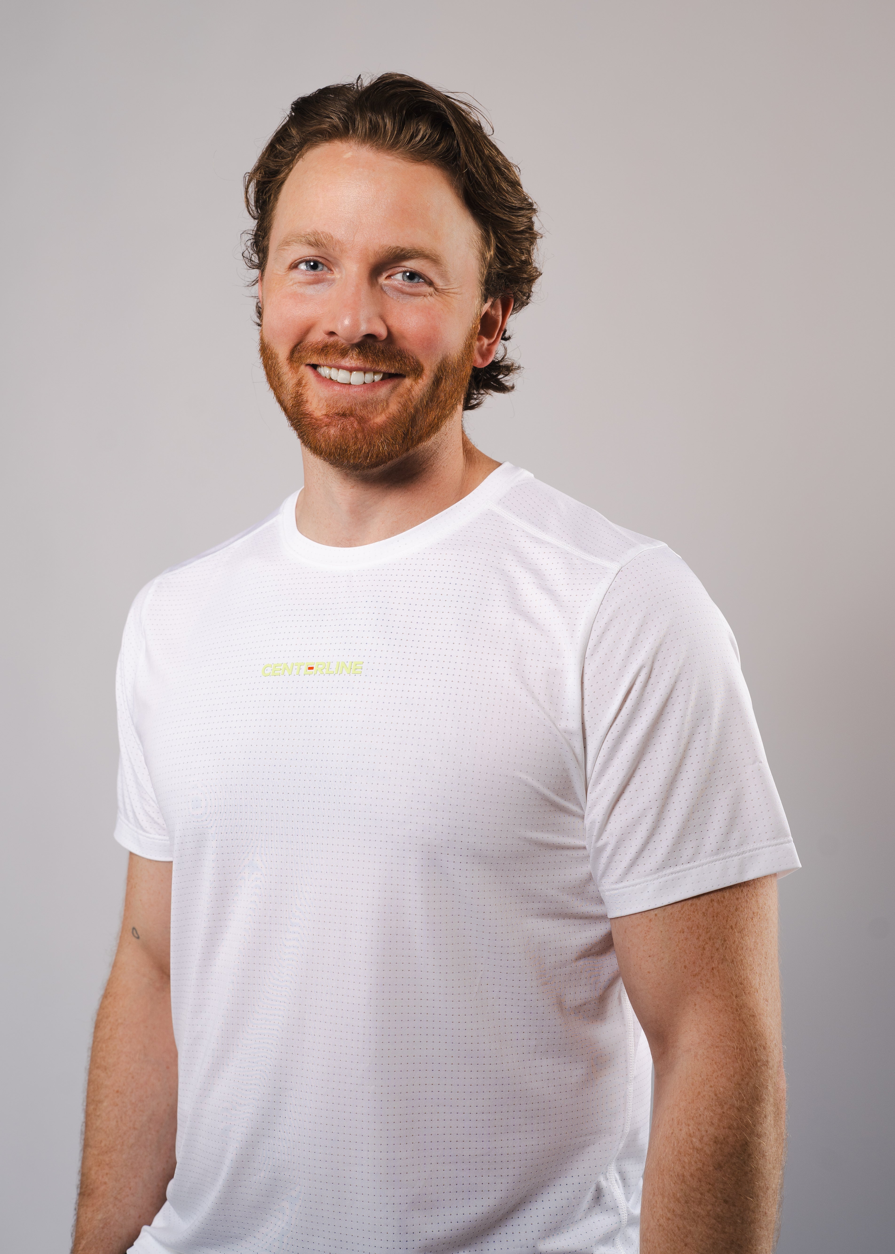 Man smiling in white t-shirt.