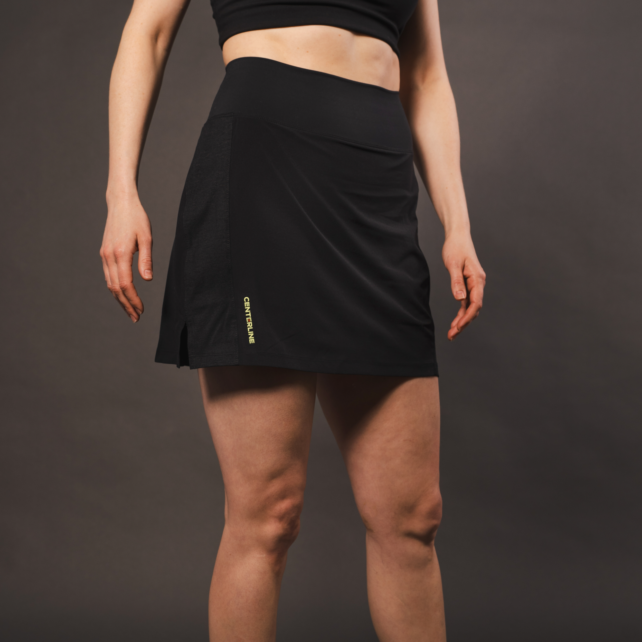 Model wearing a black sports bra and skirt.