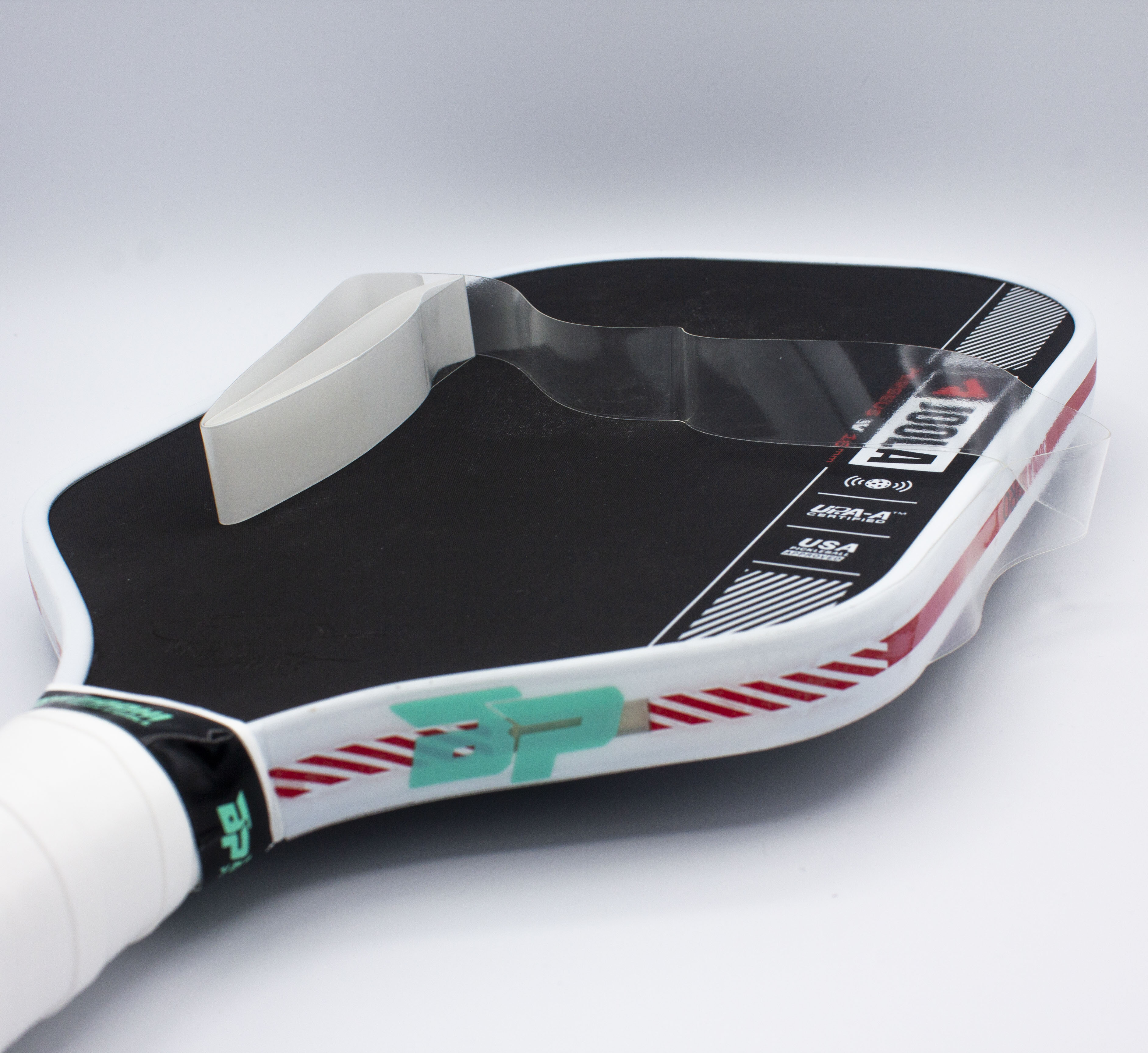 Black and white pickleball paddle with clear plastic cover.