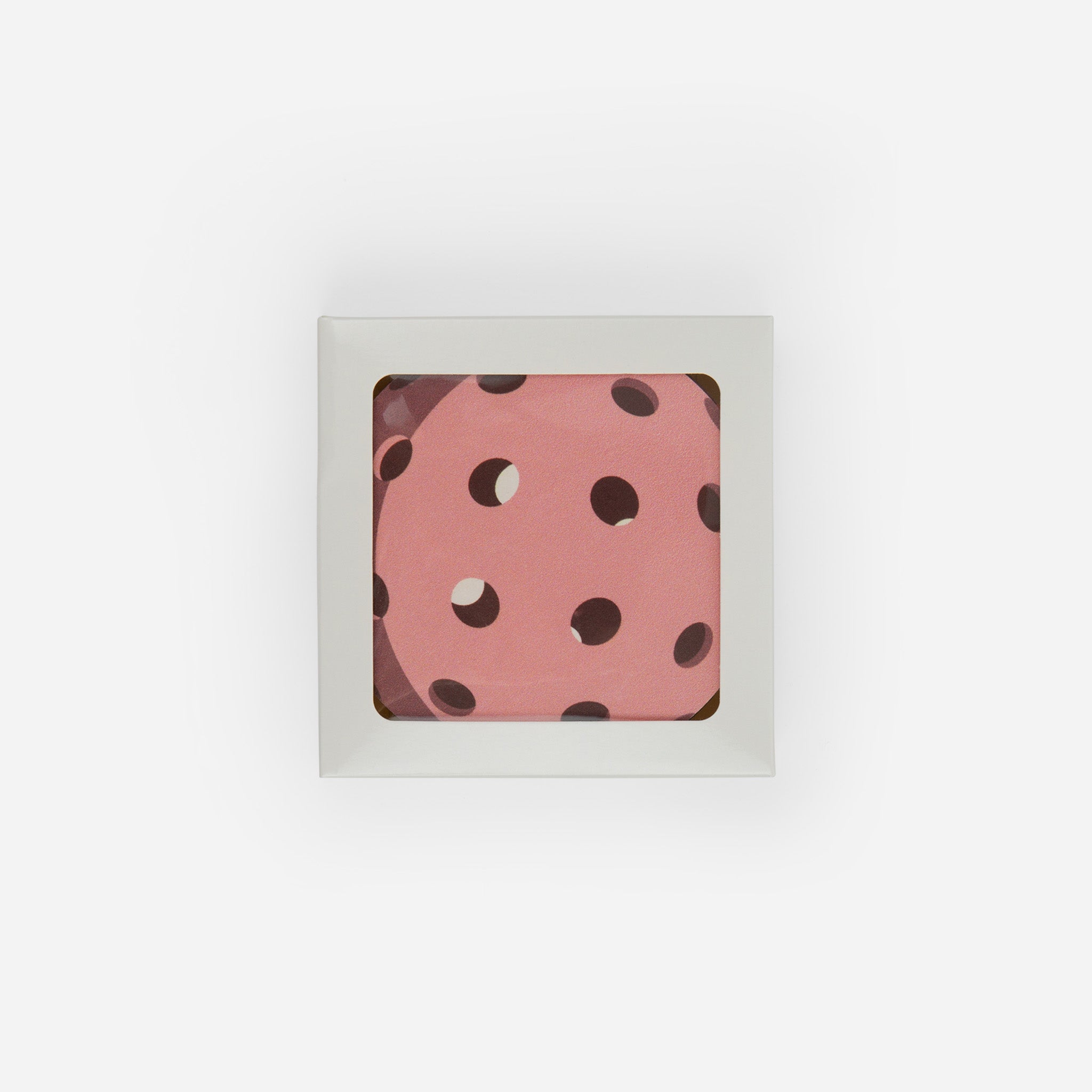 Top-down view of a coaster with a pink polka-dot pattern in a square holder.
