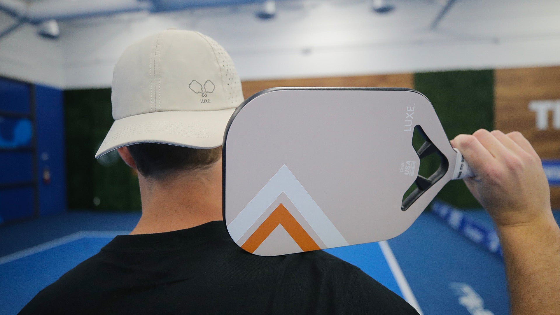 Person with hat and pickleball paddle.
