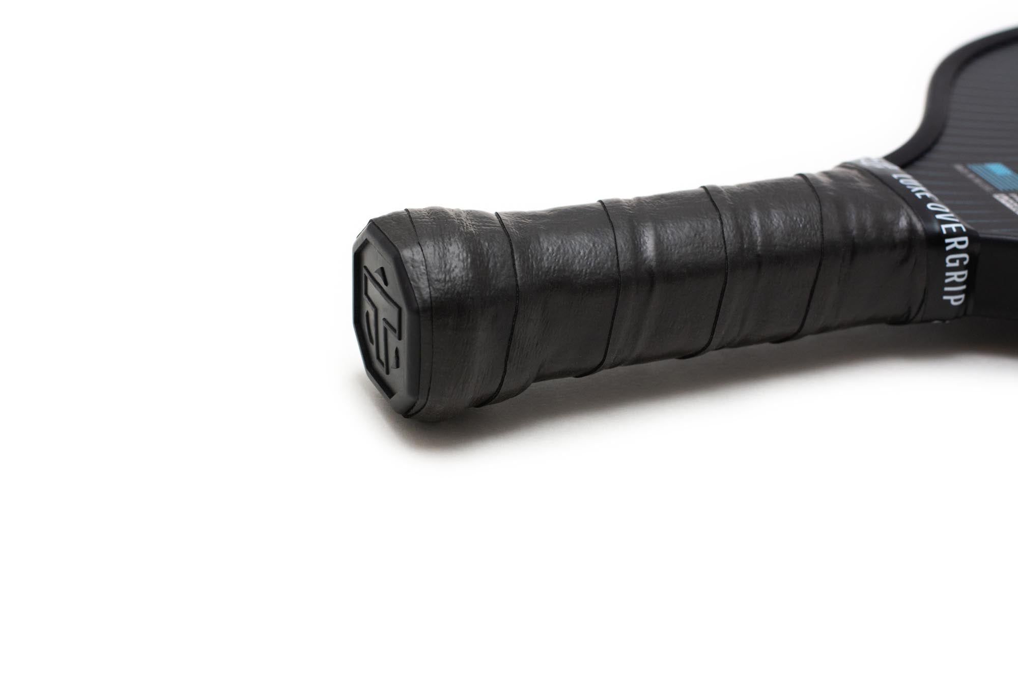 Black textured overgrip by TMPR Sports, wrapped around a paddle handle with LUXE OVERGRIP text.