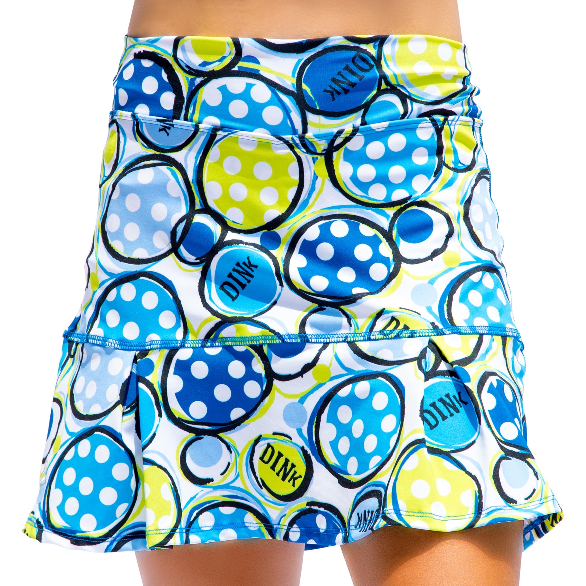 A colorful polka dot pleat skort by Pickleball Bella, featuring blue, lime green, and white circles, some with "DINK" text, and drop pleats.