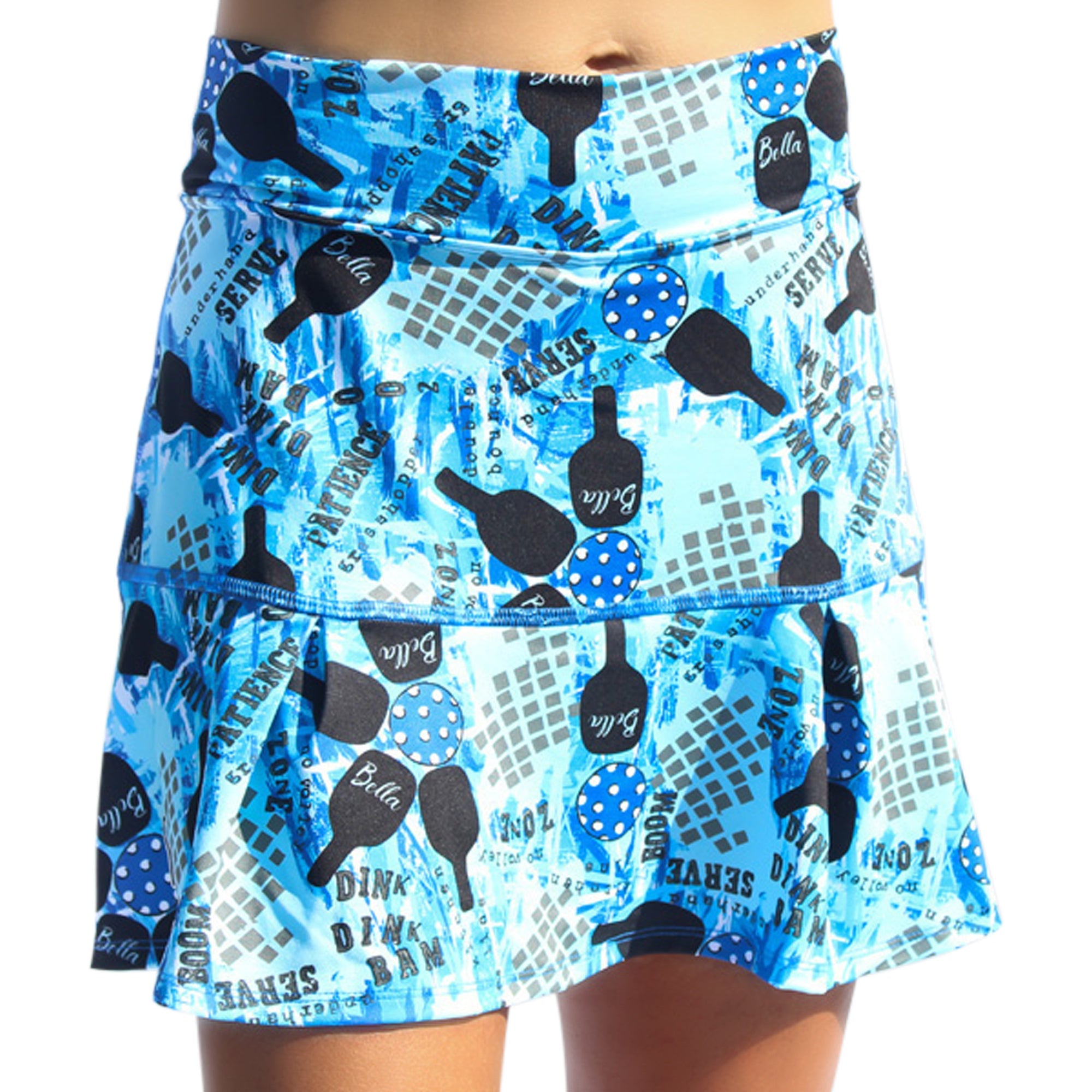 Blue drop pleat skort by Pickleball Bella featuring pickleball paddles, balls, and terms on a vibrant graffiti background.