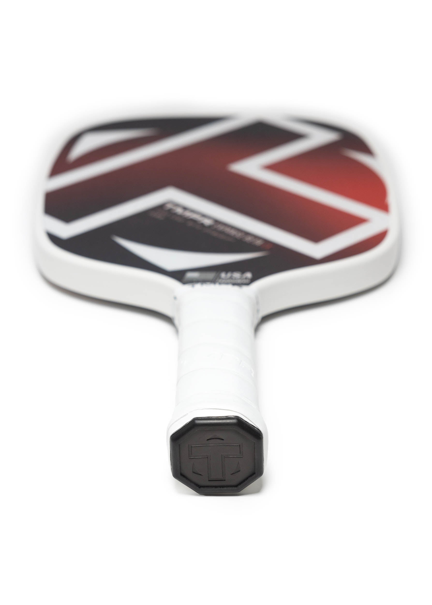 White-gripped pickleball paddle by TMPR Sports with a black and red geometric face, shown from the handle.