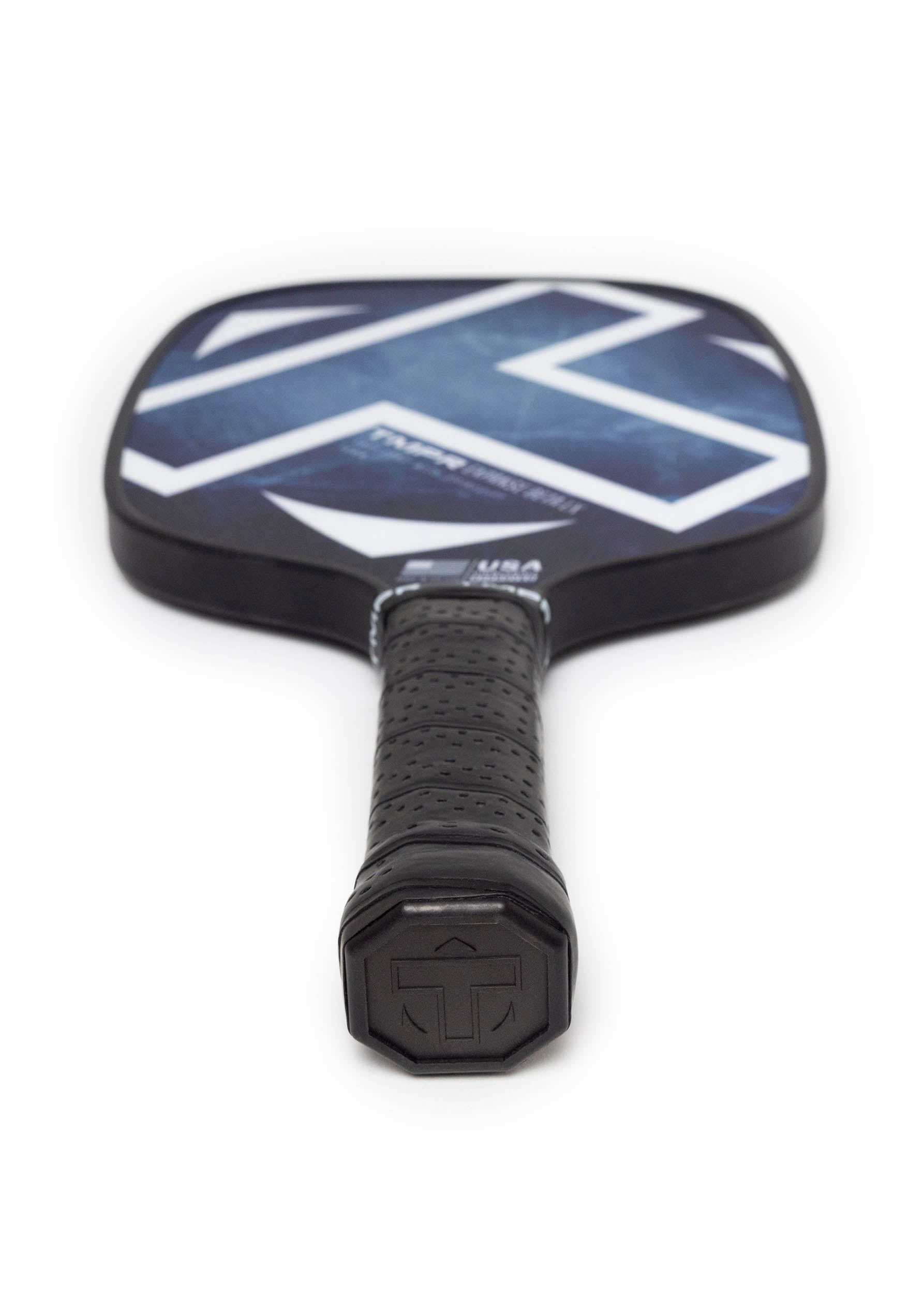 Dark blue and black pickleball paddle by TMPR Sports featuring a white geometric pattern, textured black grip, and handle logo, viewed from a low angle.