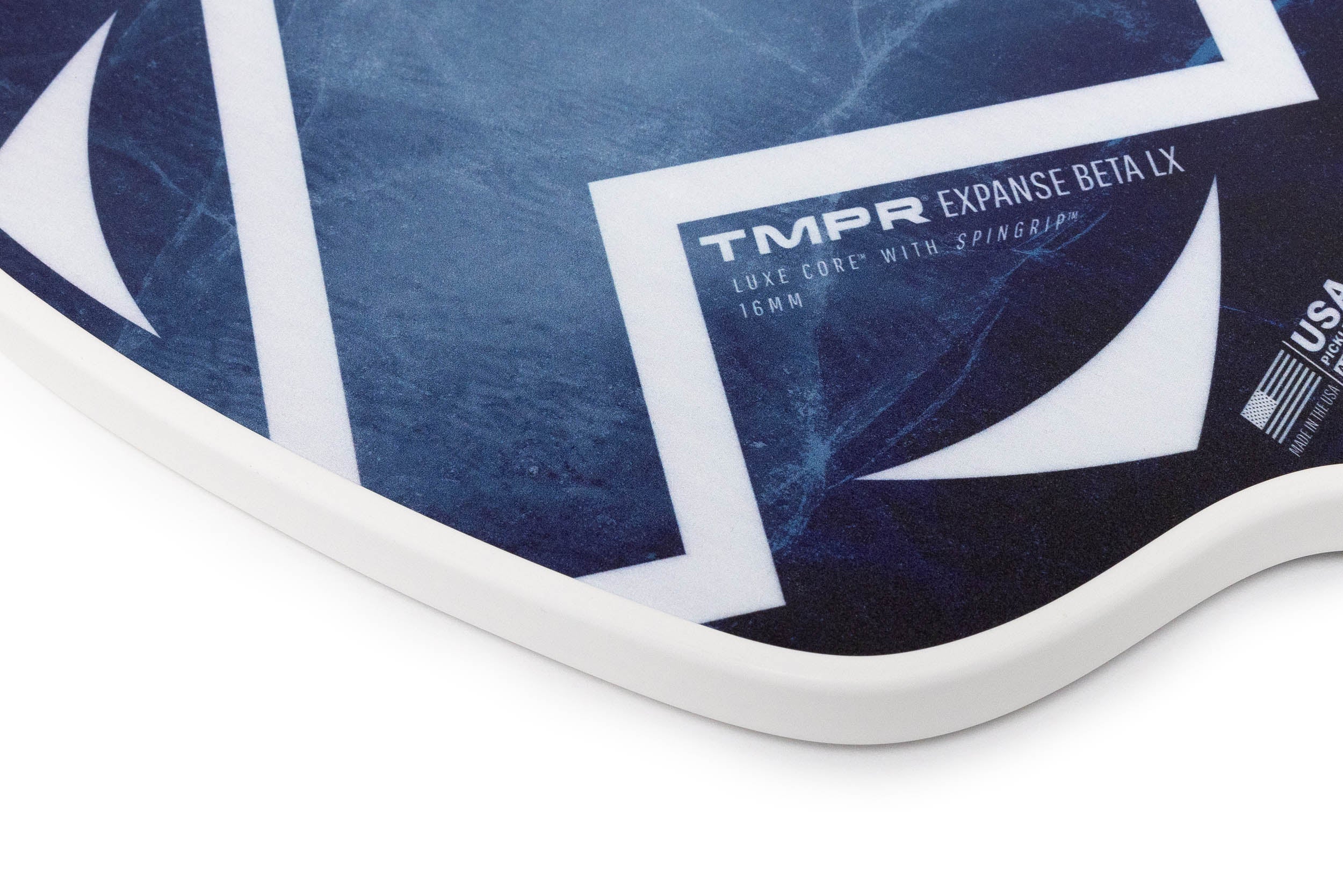 Indigo blue and white pickleball paddle by TMPR Sports, with a geometric pattern, white edge guard, and 'Expanse Beta LX' text.