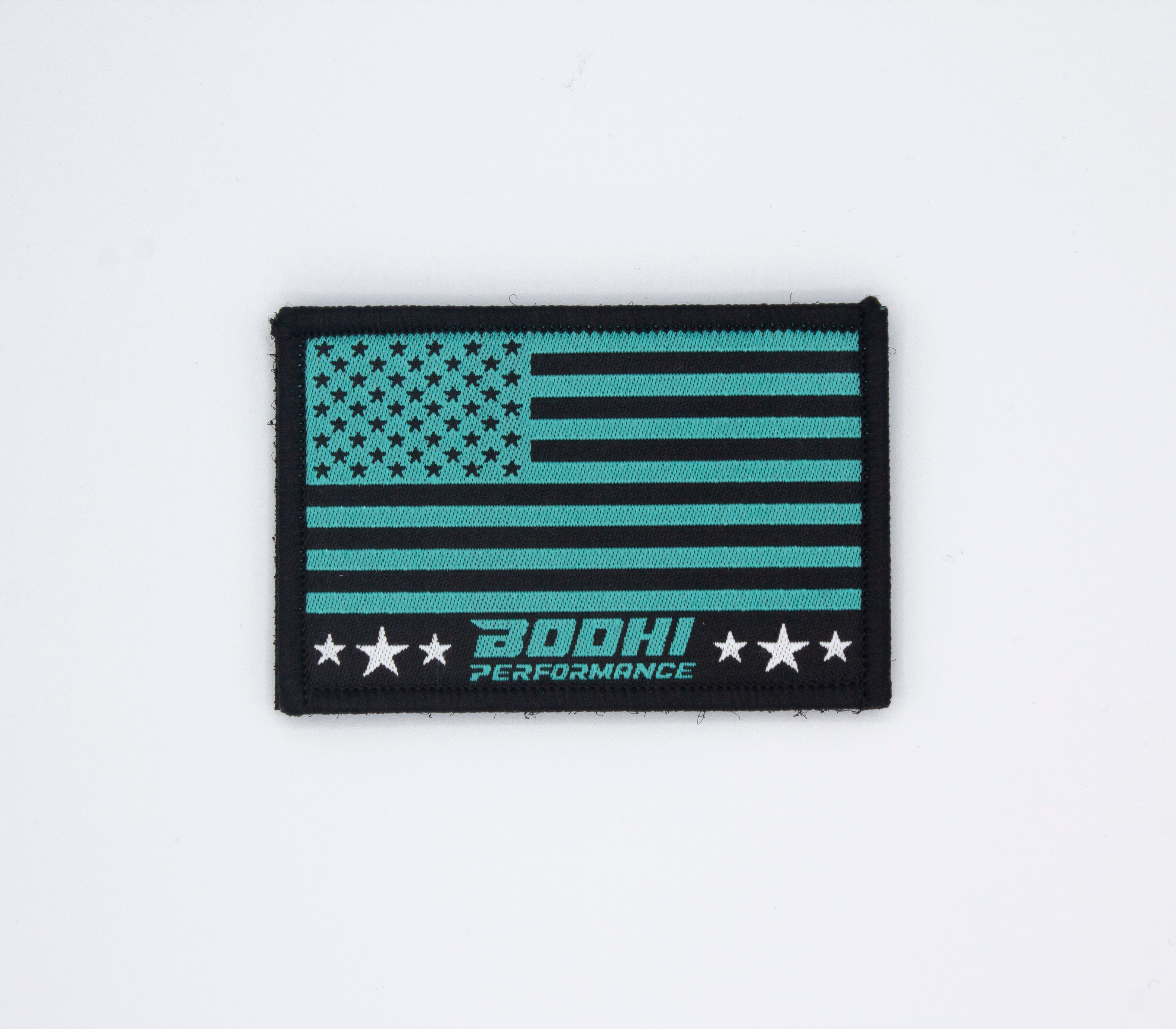 Teal and black American flag Velcro patches by Bodhi Performance, embroidered with stars, stripes, logo, and three white stars.