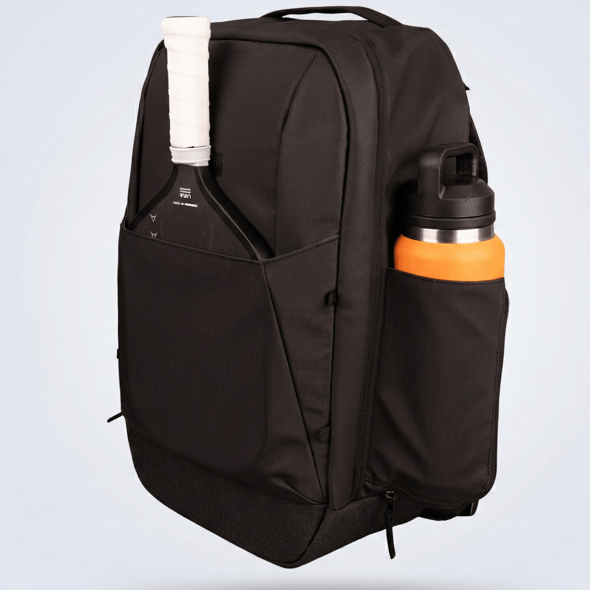 Black pickleball backpack by FORWRD with a pickleball paddle and orange water bottle in side pockets, side view.