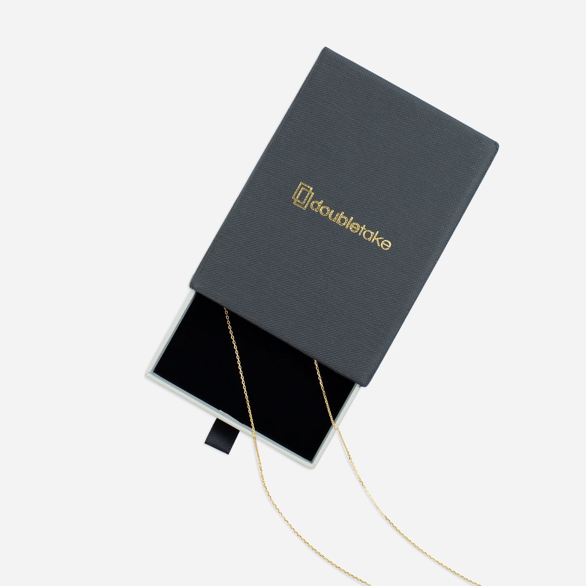 Open gray jewelry box with gold necklace.