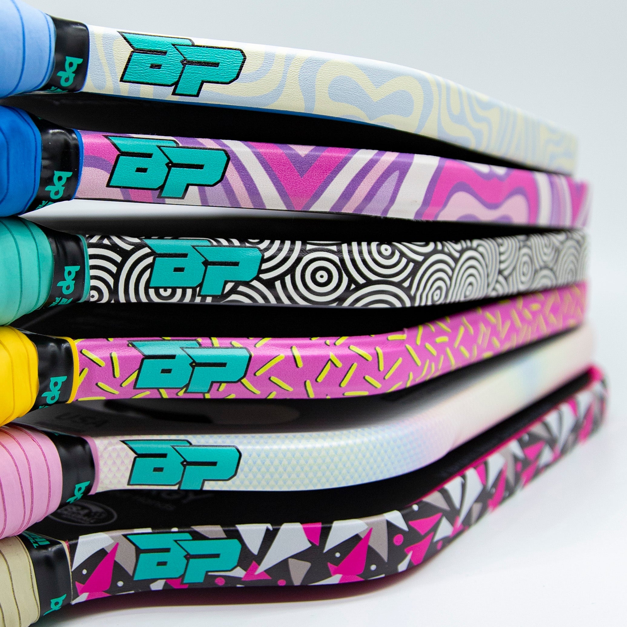 Stack of colorful patterned pickleball paddles.
