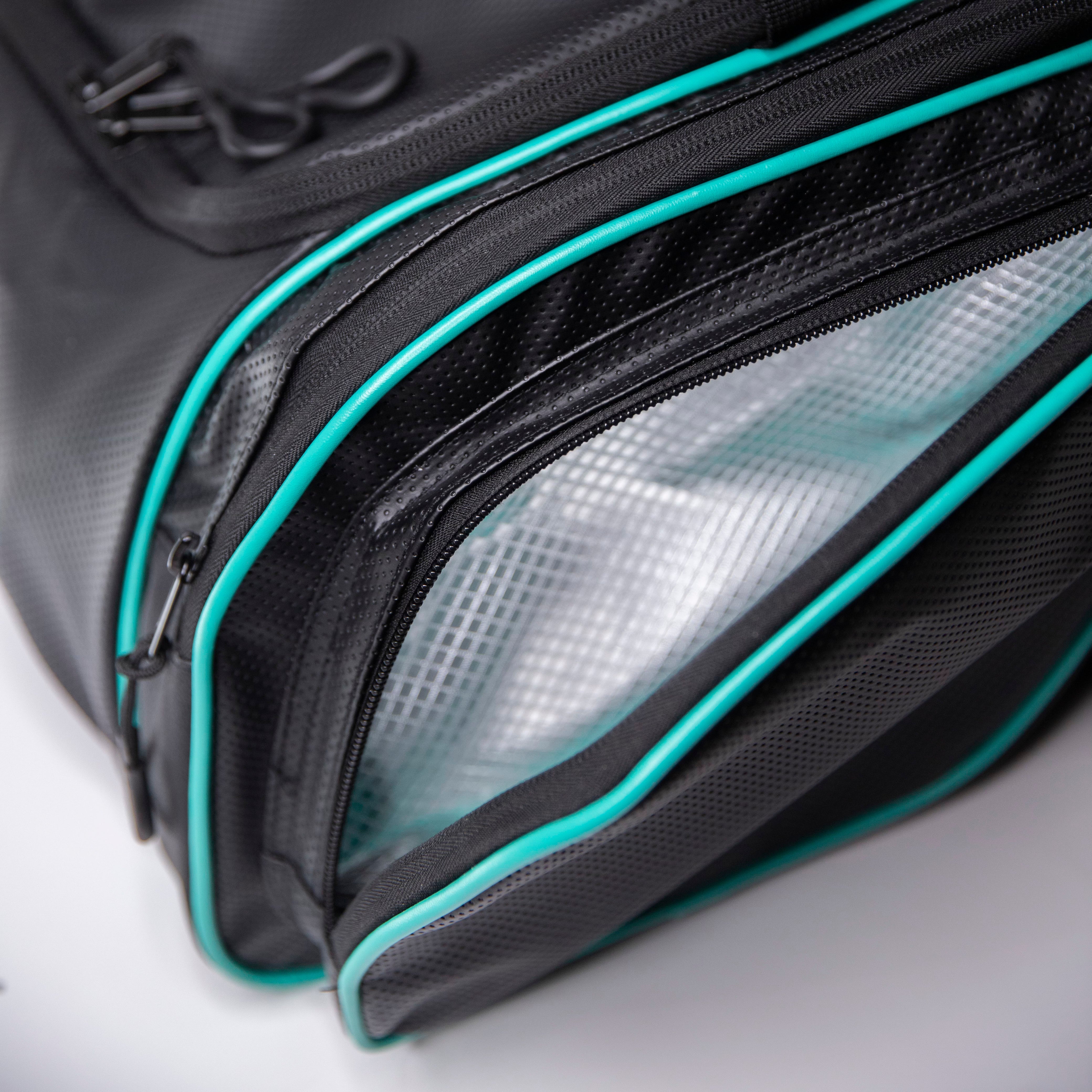 Close-up of a black bag with turquoise trim and an open mesh interior.
