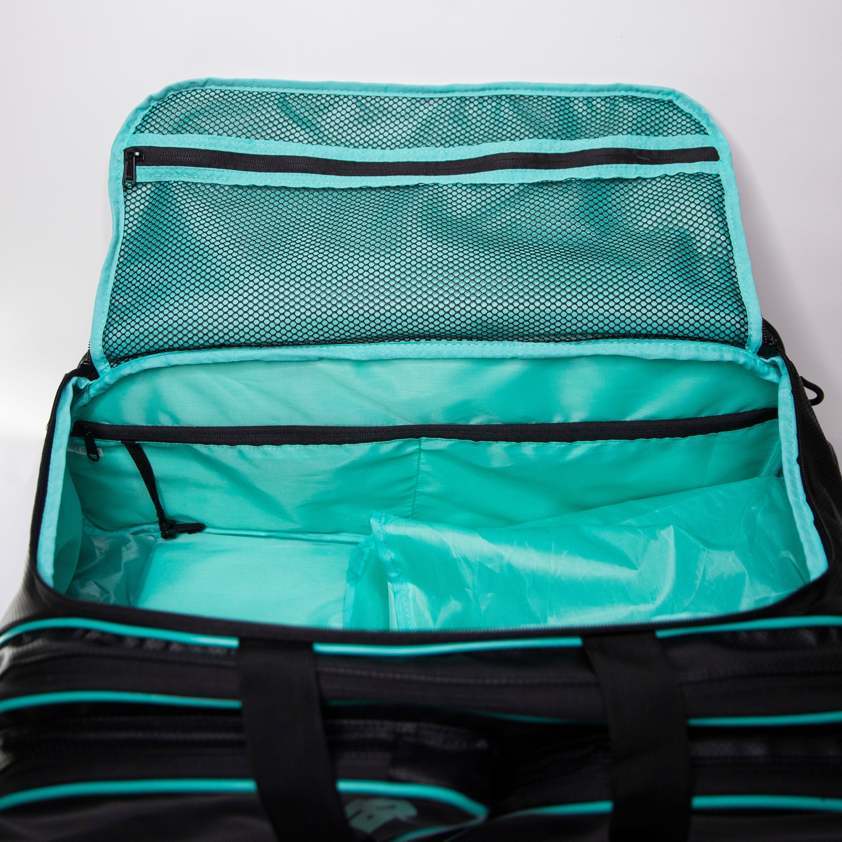 Open black duffel bag with turquoise lining and mesh pockets.