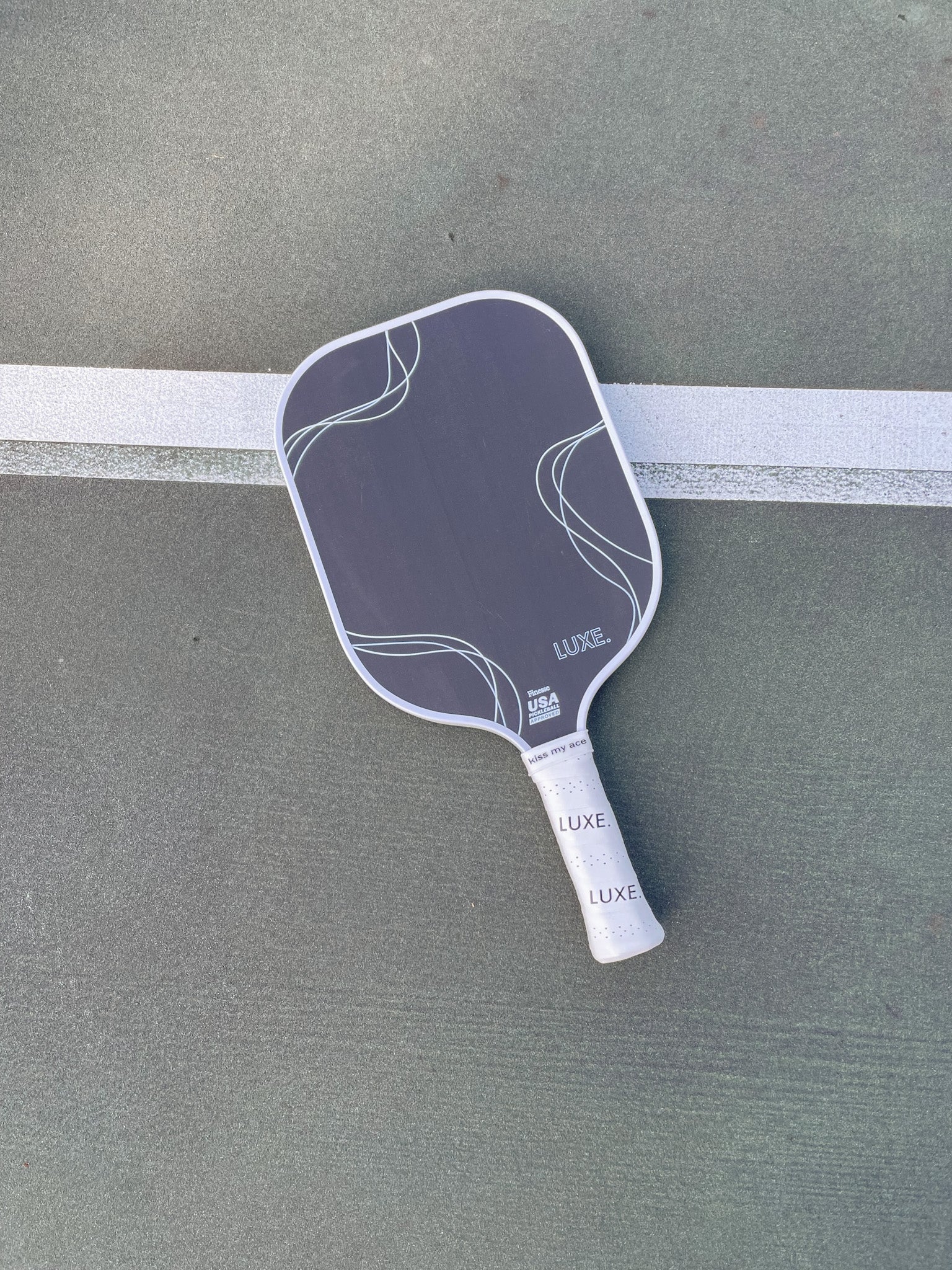 Pickleball paddle on an outdoor court.