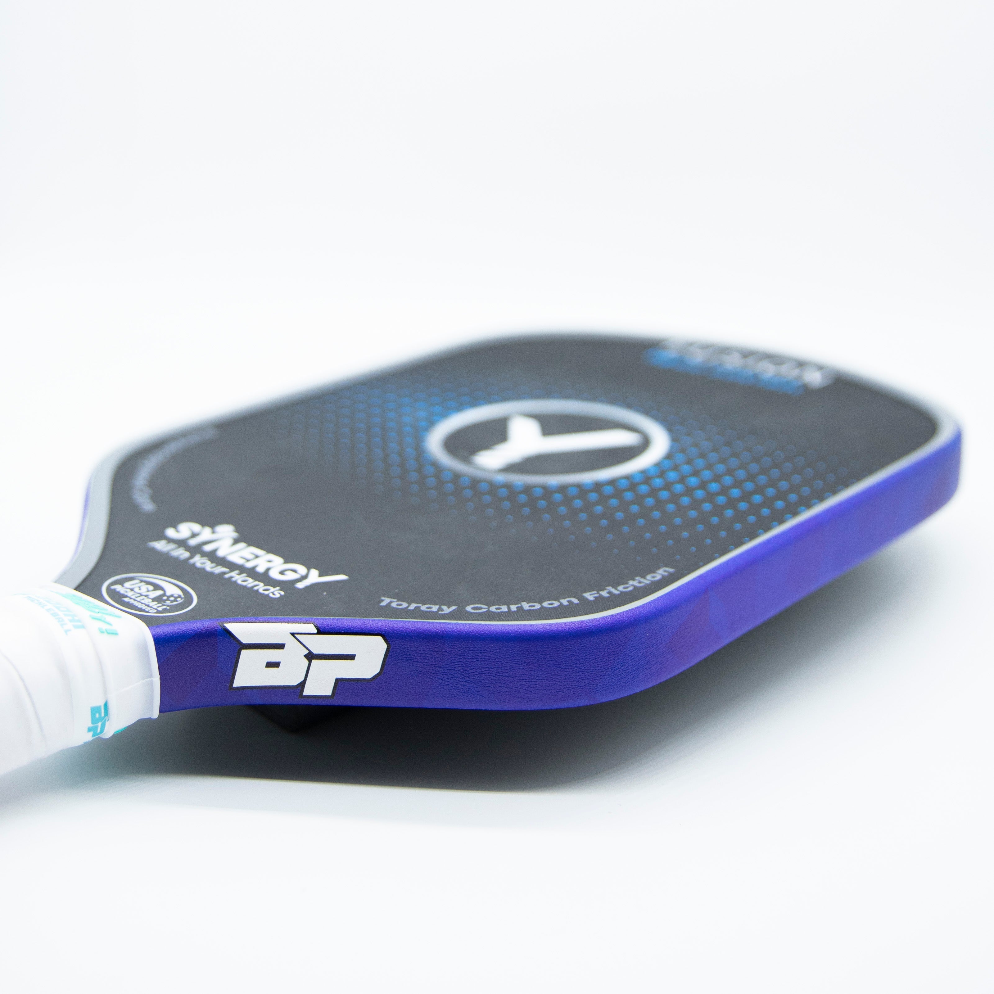 Pickleball paddle with purple trim, white grip, and black face with blue dots.