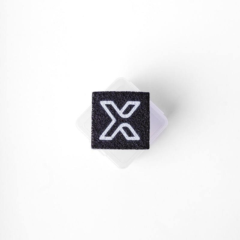 Black square with a white X on a clear plastic container.