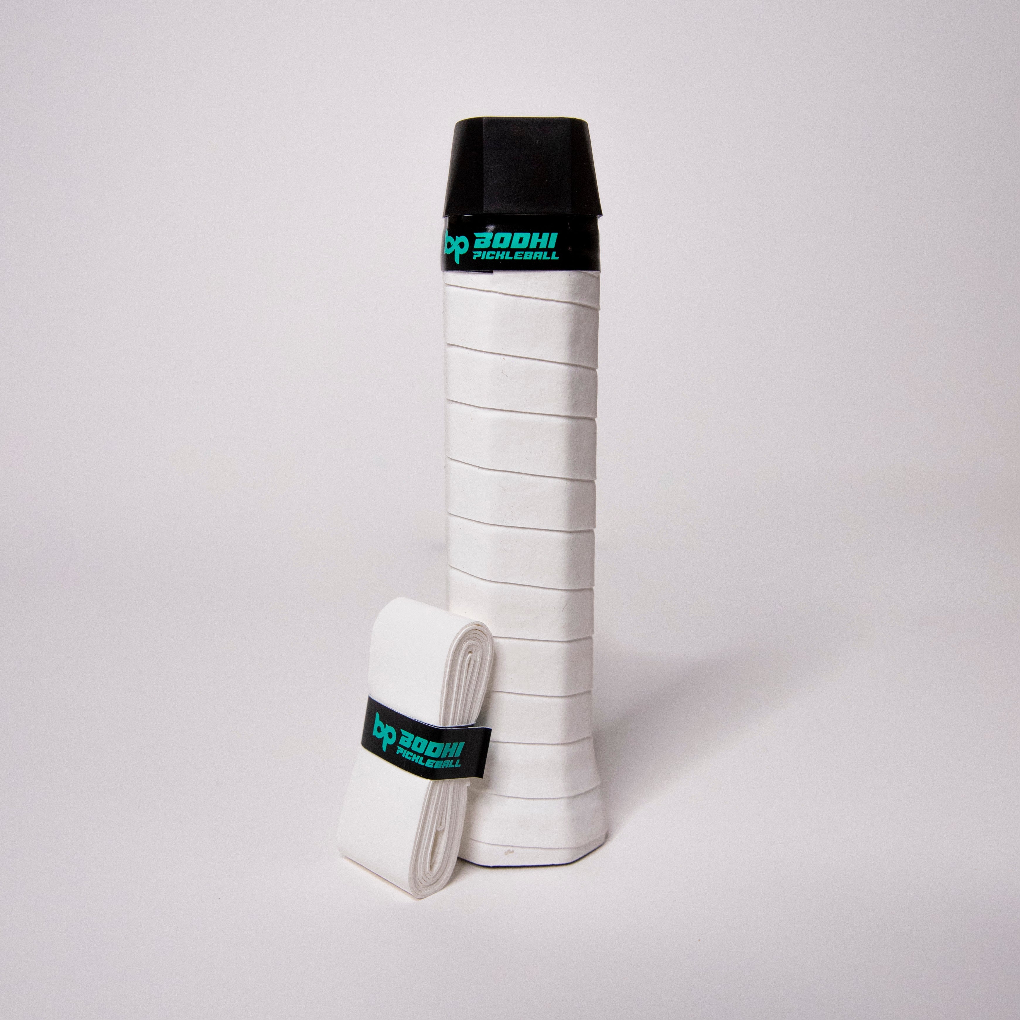 A white pickleball grip wrap with a black top, with a smaller rolled wrap to the left.