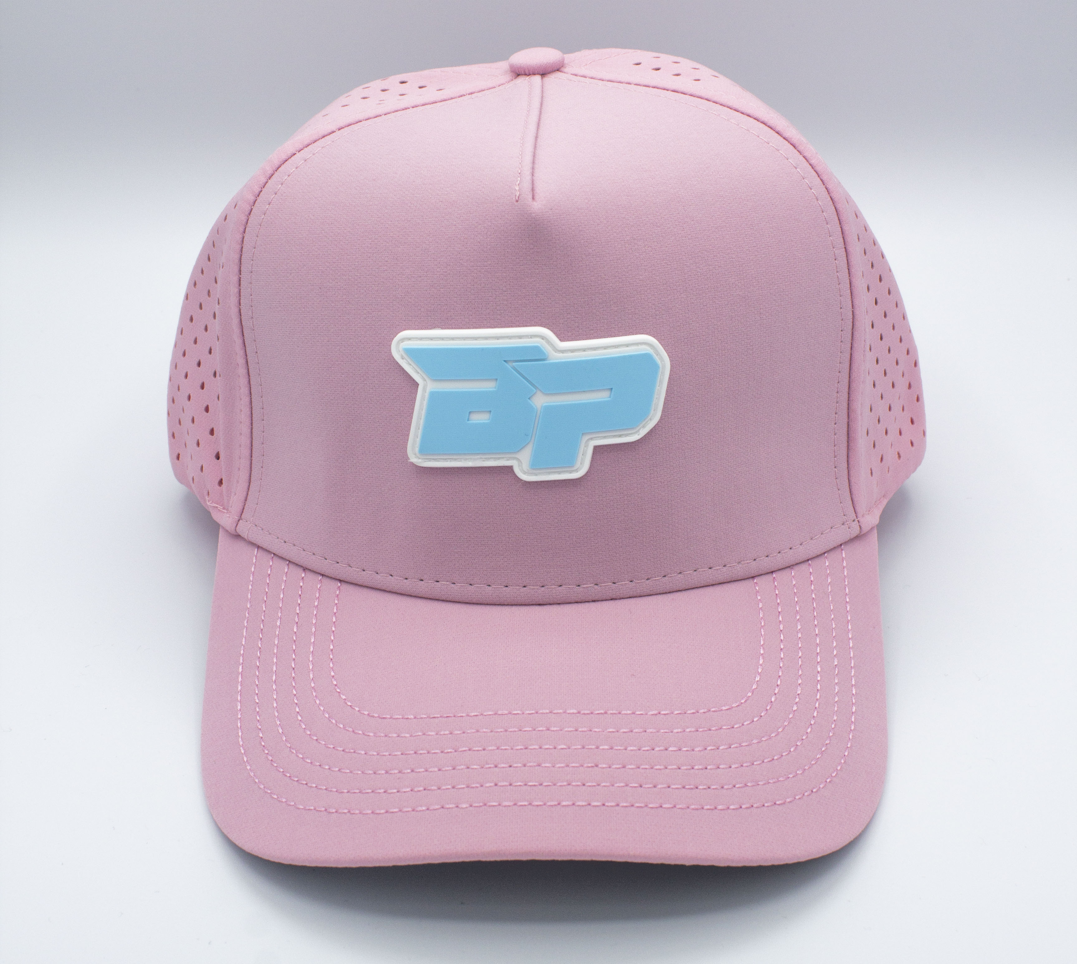 Front view of a pink baseball cap with a blue and white logo on a white background.